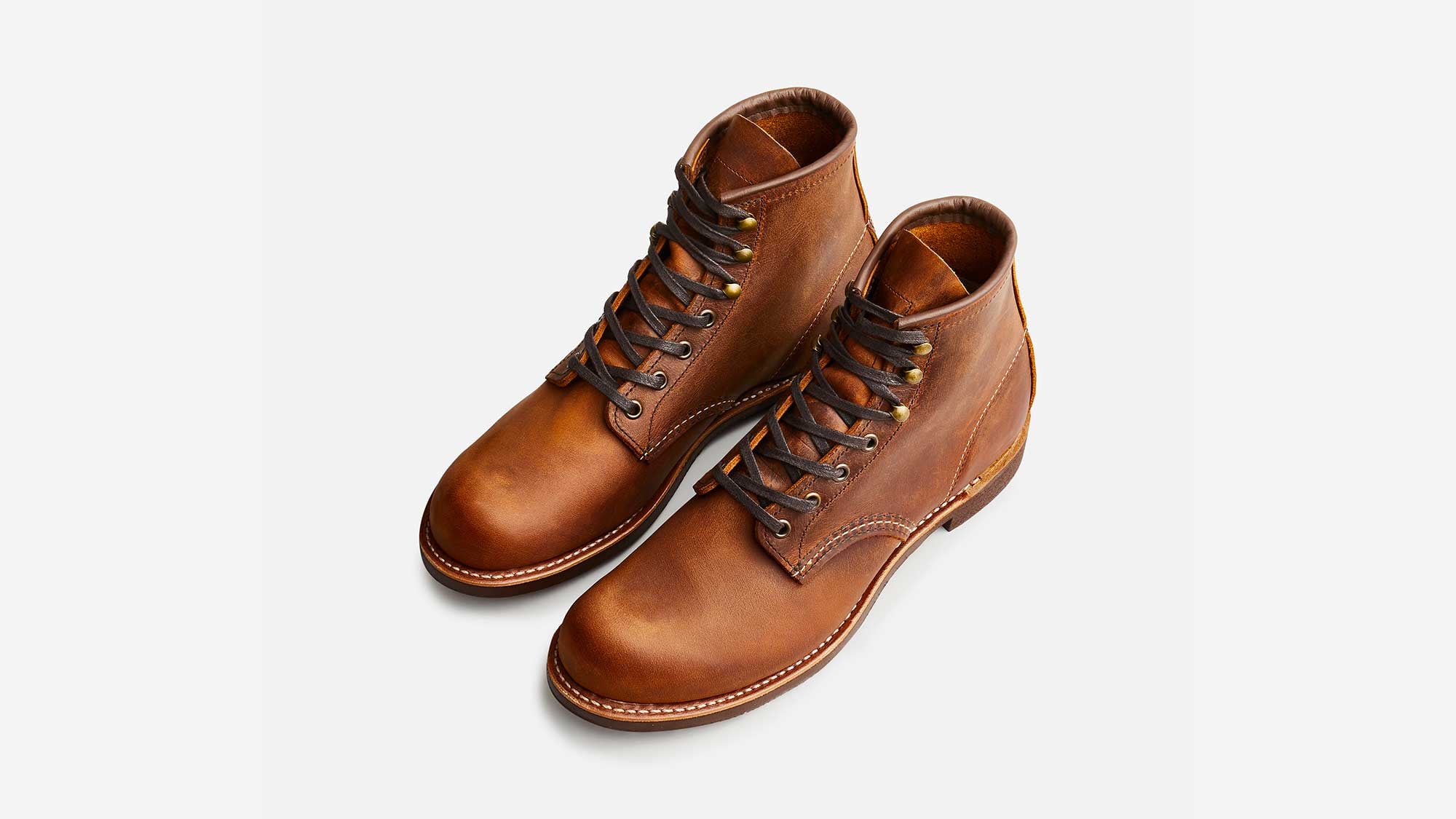 The Blacksmith 3343 pair seen from above on a light grey background: rounded plain toes, brass eyelets and speed hooks, dark laces and the burnished copper leather catching the light on the toes