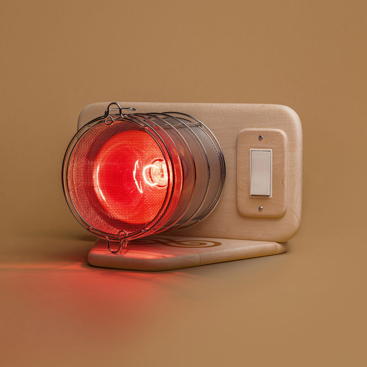 SaunaSpace Glow: a red-glowing incandescent bulb inside a round stainless steel mesh guard, mounted on a light basswood panel with a wall-style switch and a wooden base
