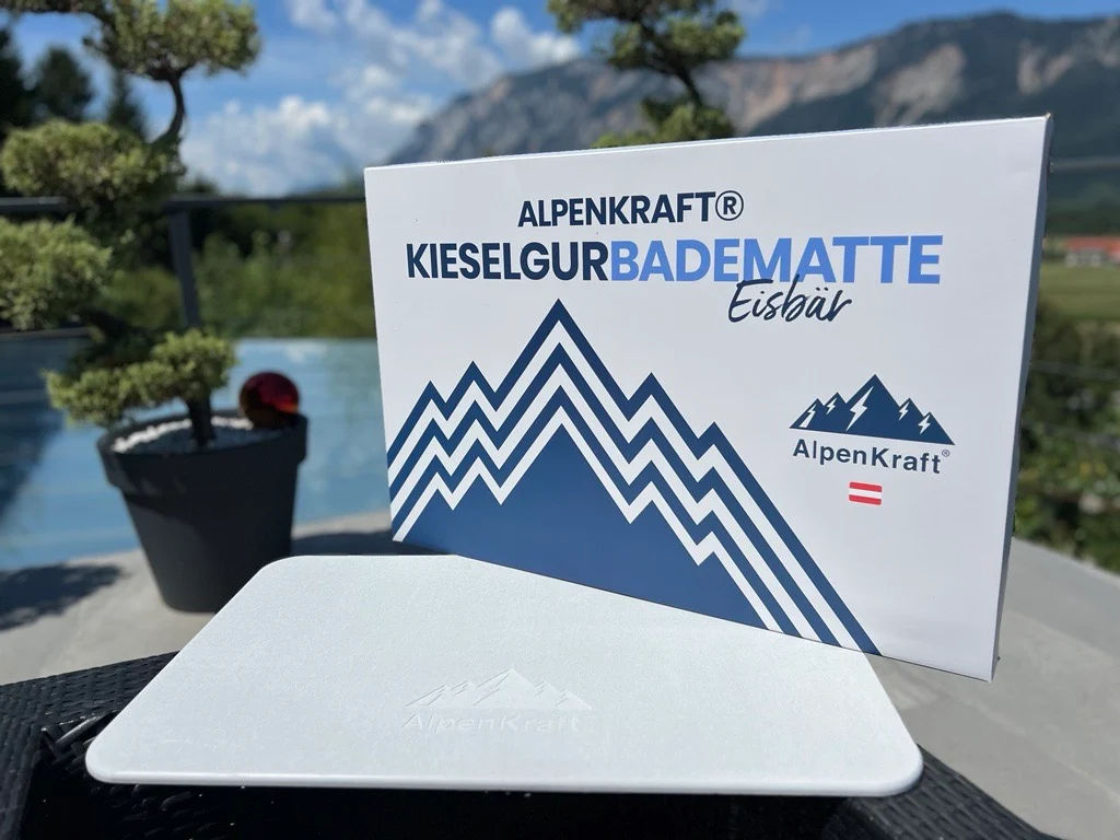 Alpenkraft Steinmatte diatomaceous earth bath mat propped against its box on a terrace table