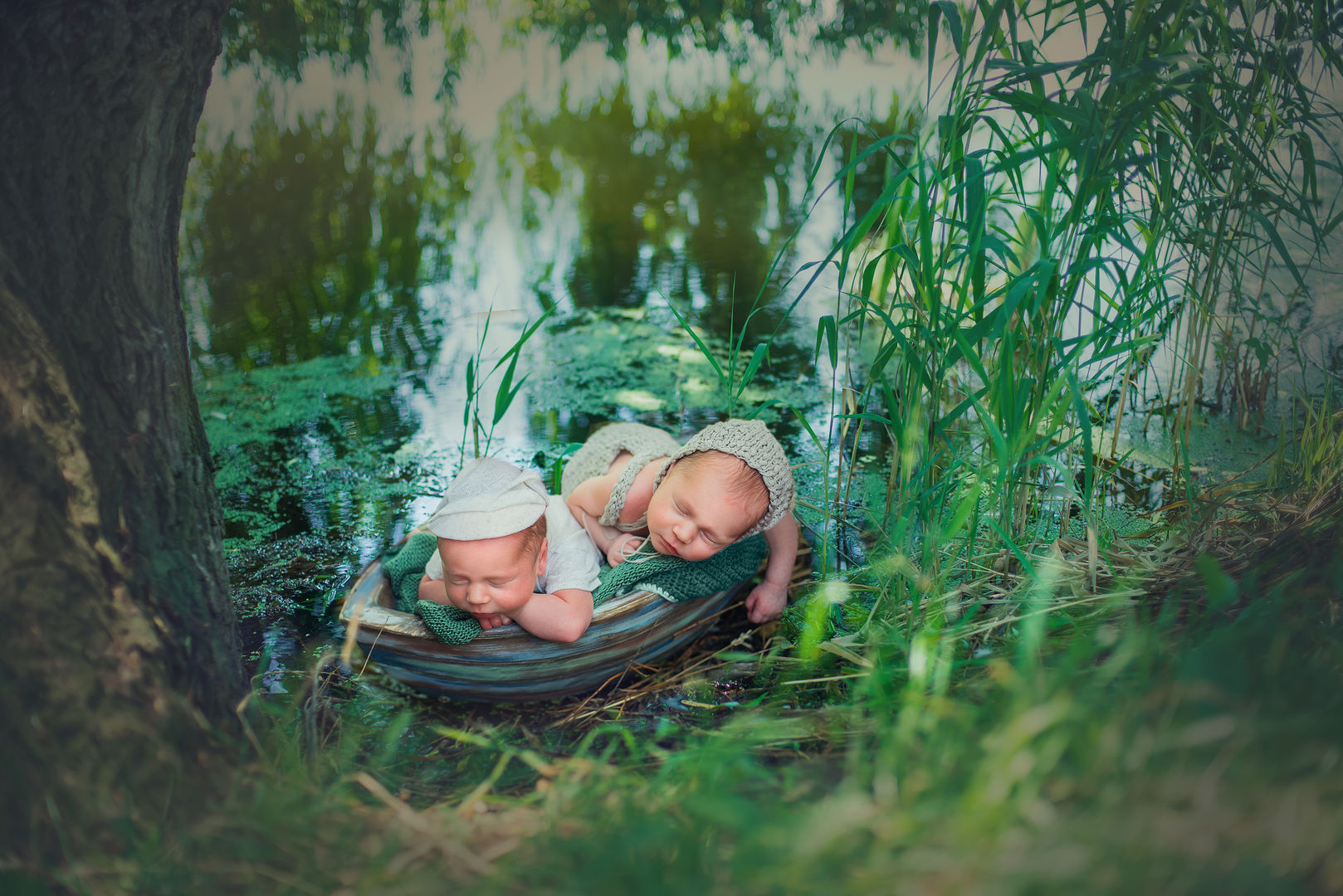 Twin newborns in boat with bonnets - classic outdoor baby photography Los Angeles