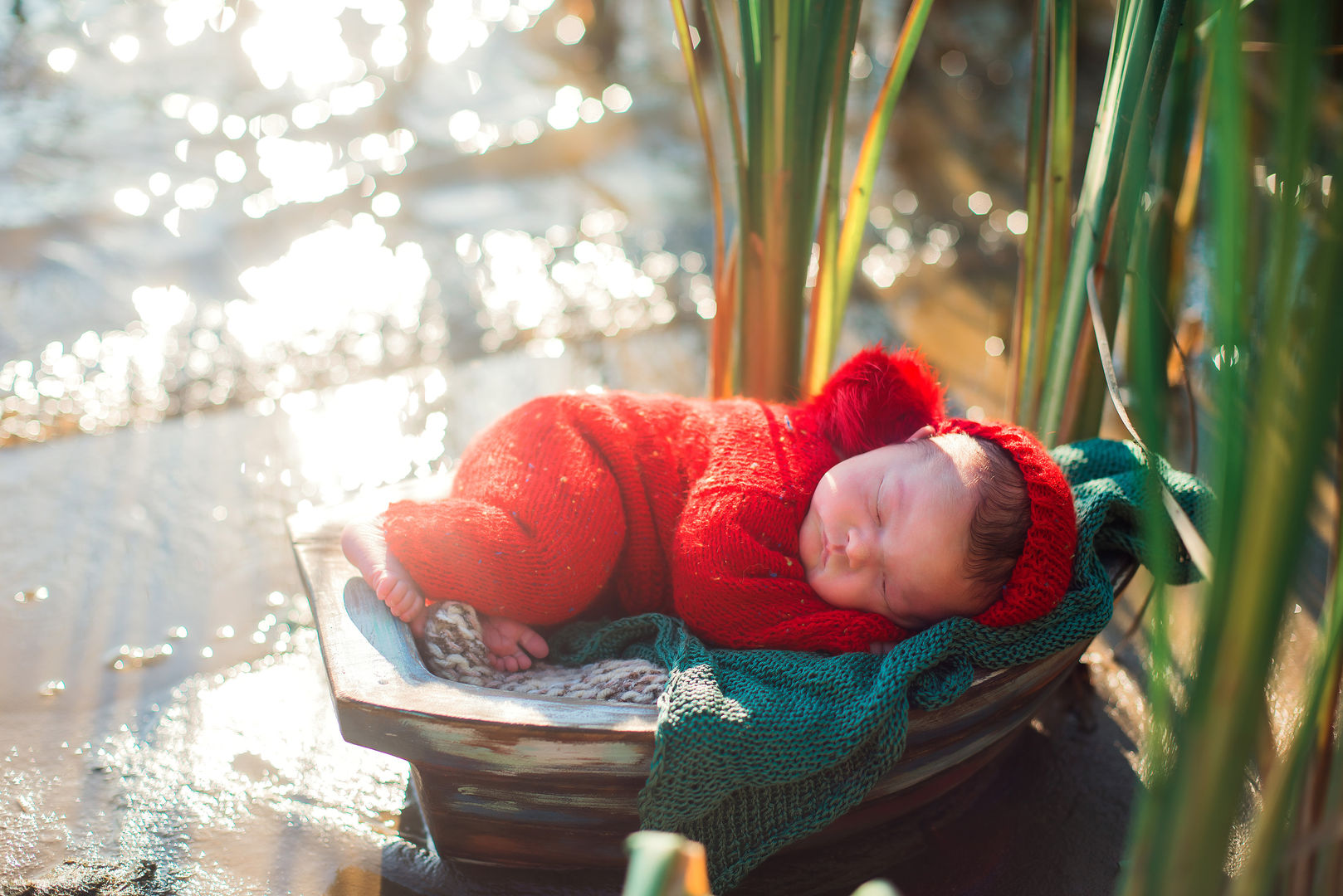 Newborn in red outfit in boat - outdoor baby photography Los Angeles