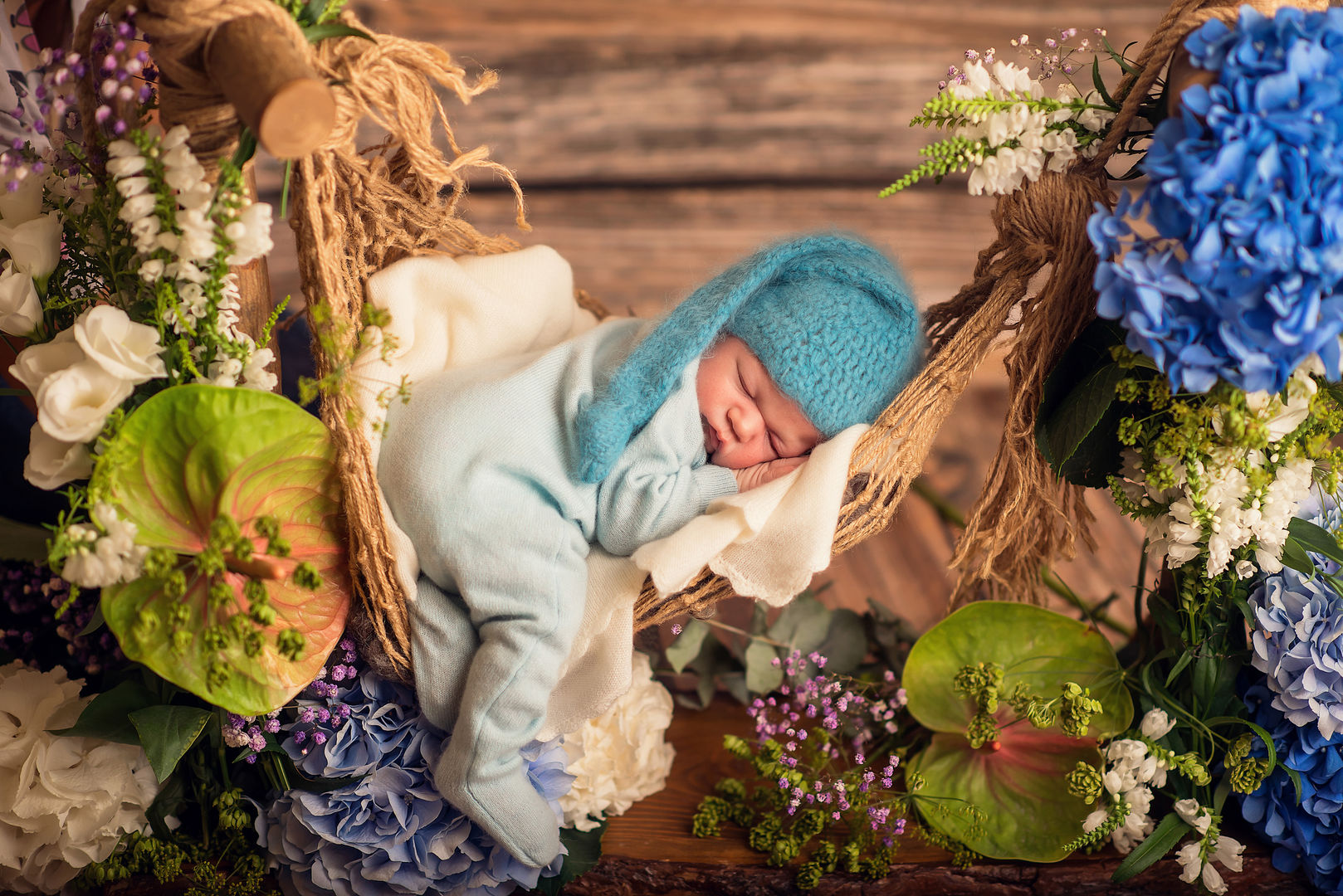 Newborn baby in basket with hydrangeas - artistic photography Los Angeles