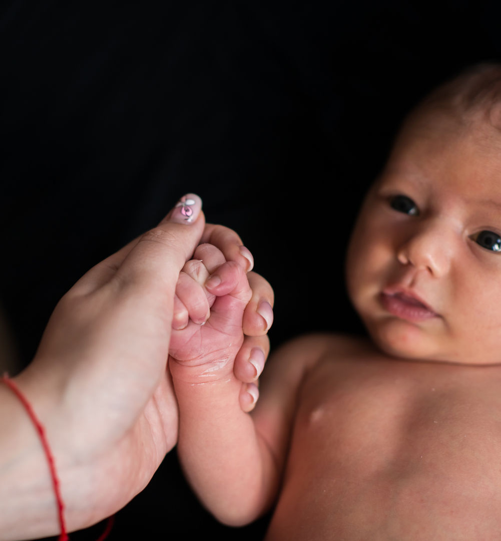Parent holding newborn baby's tiny foot