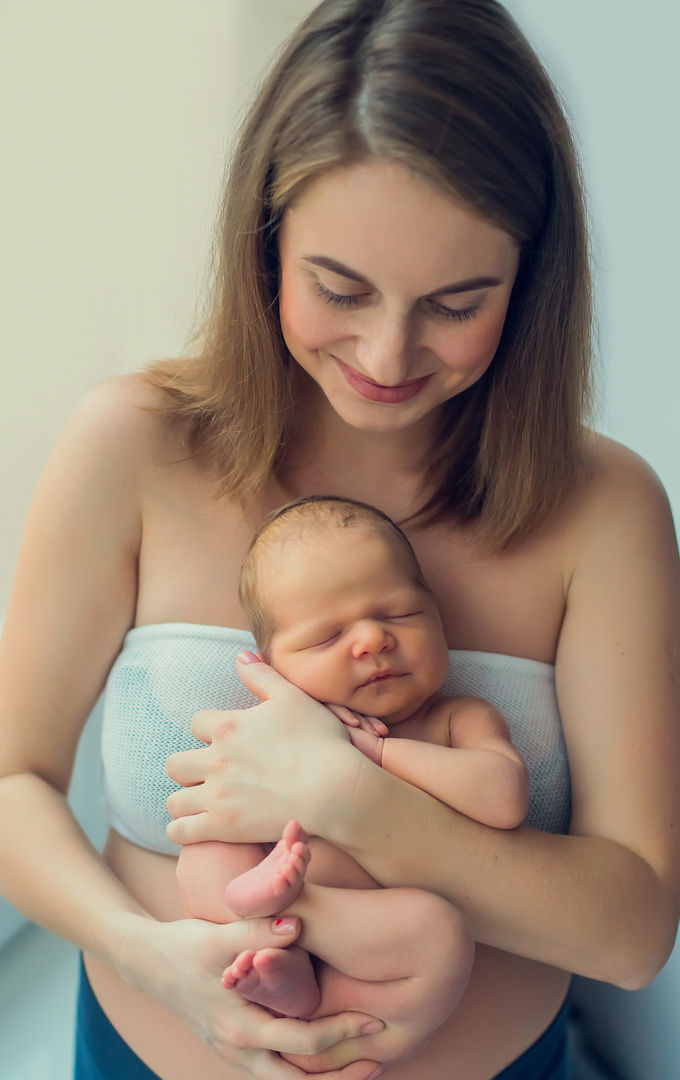 Mother gazing down at newborn in her arms