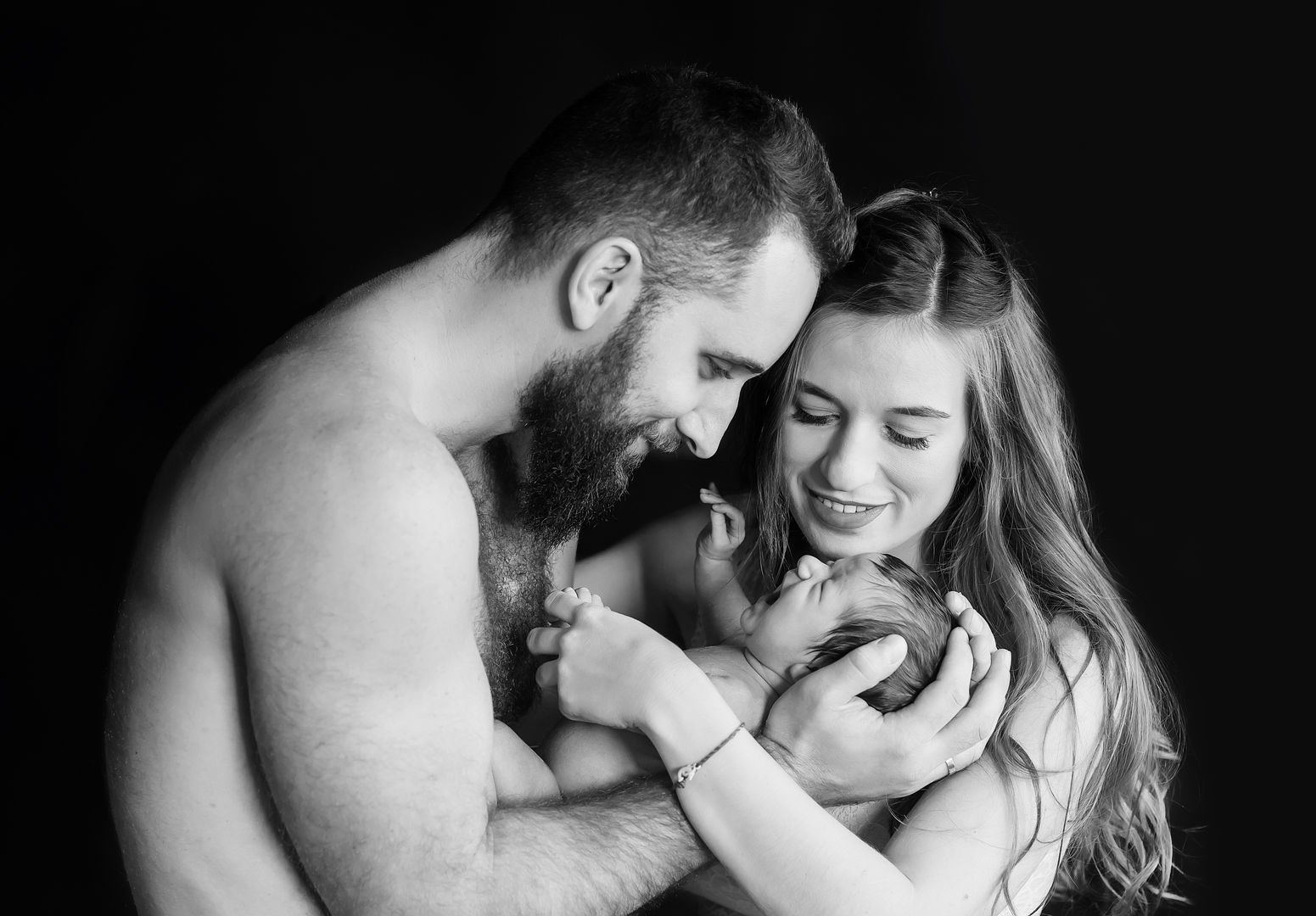 Couple holding their newborn baby together