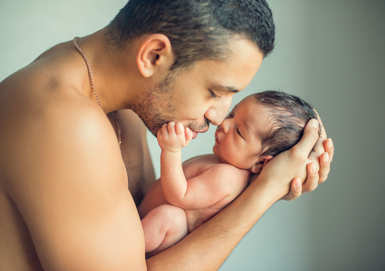 Father gazing lovingly at newborn baby