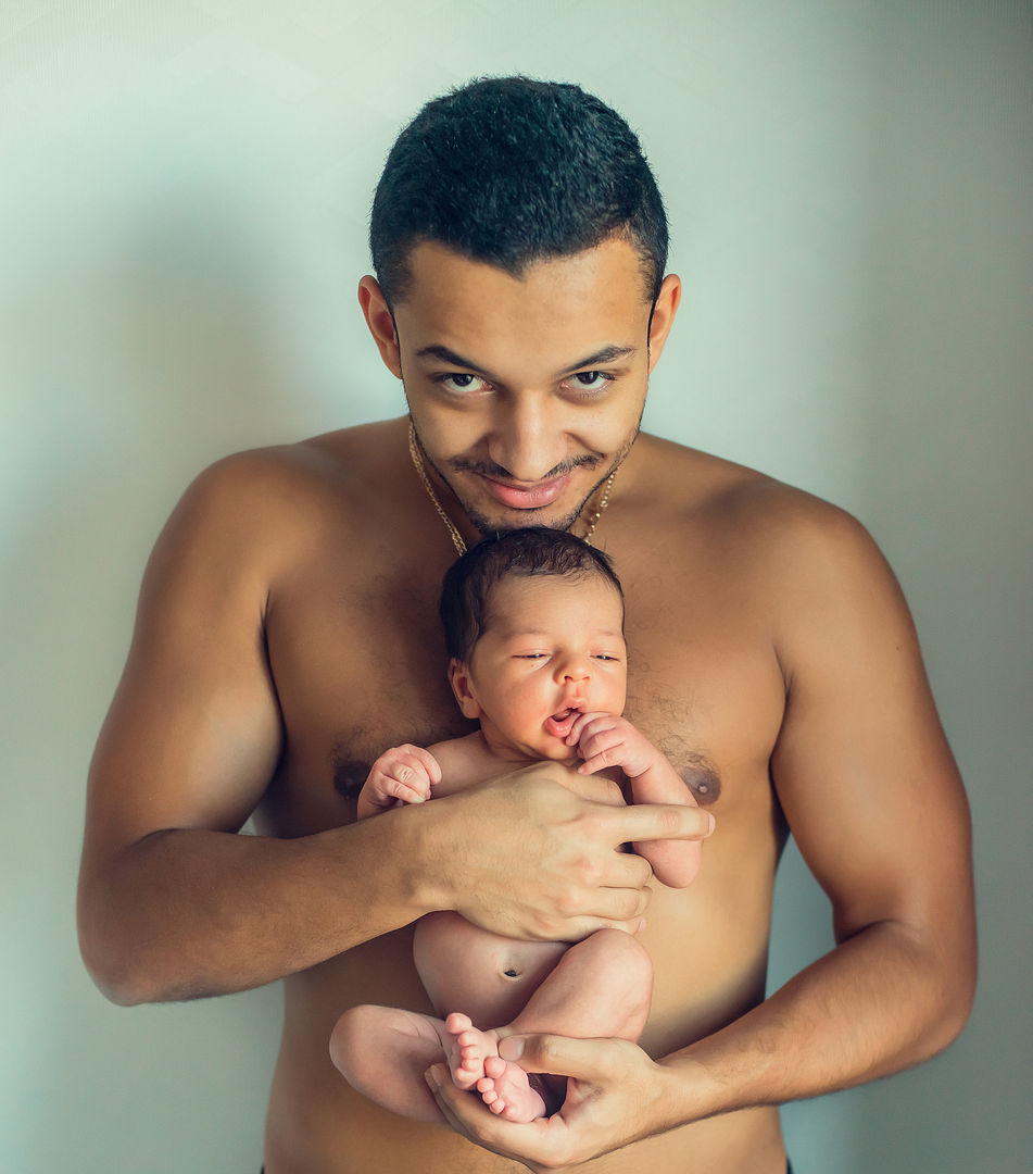 Father tenderly holding newborn baby in lifestyle portrait