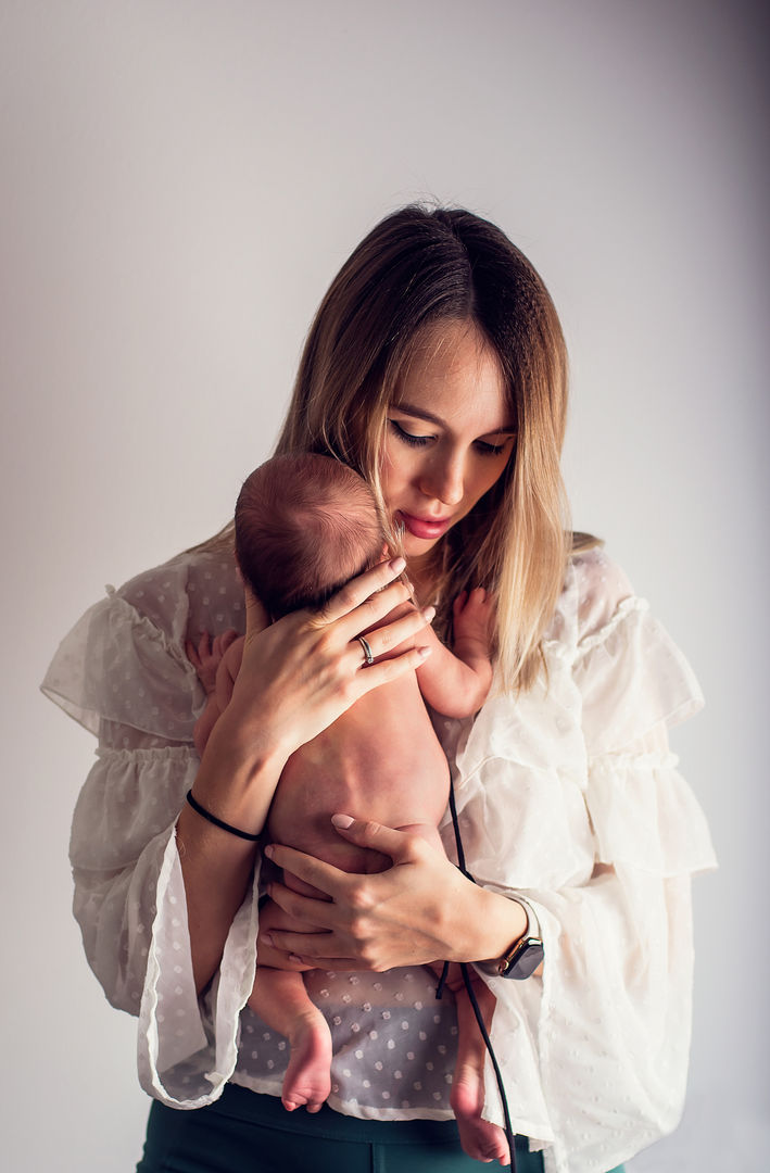Mother holding newborn against shoulder
