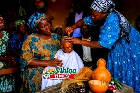 African newborn baby during traditional hair shaving or naming ceremony - cultural practice balanced with modern medical safety guidelines for infant care in Kenya
