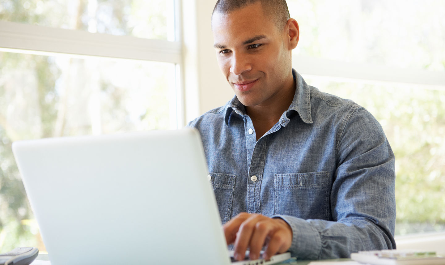 A man sitting at a table on his laptop