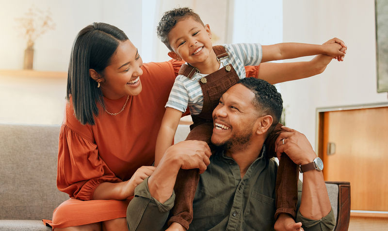 A father, mother, and son playing together in their living room