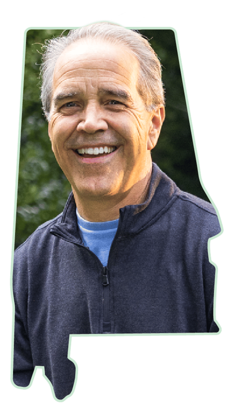 A portrait of a smiling member framed inside the outline of the state of Alabama.