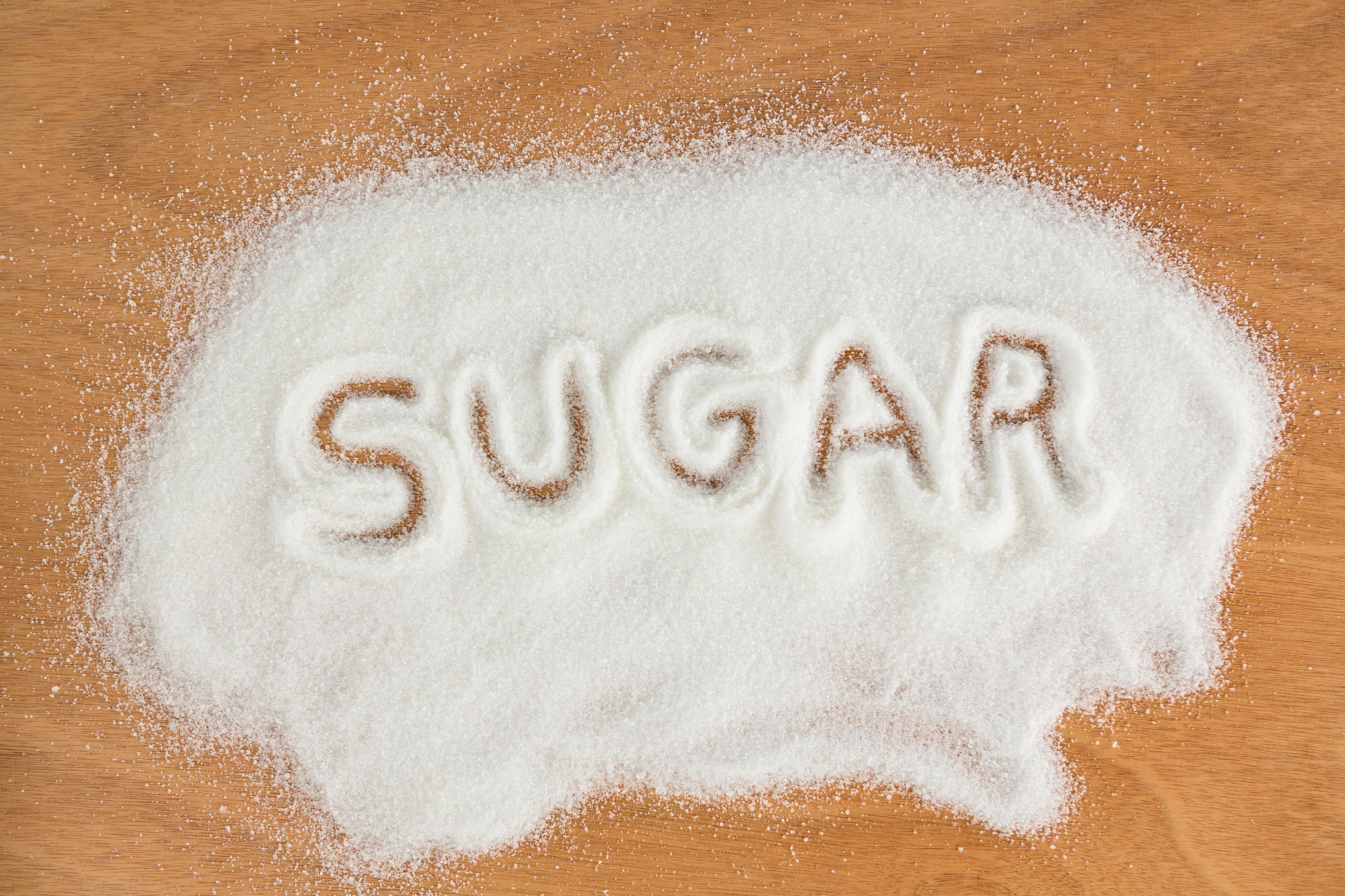 The word SUGAR written in white sugar powder — understanding what sugar-free actually means on a supplement label requires checking the Total Sugars line directly