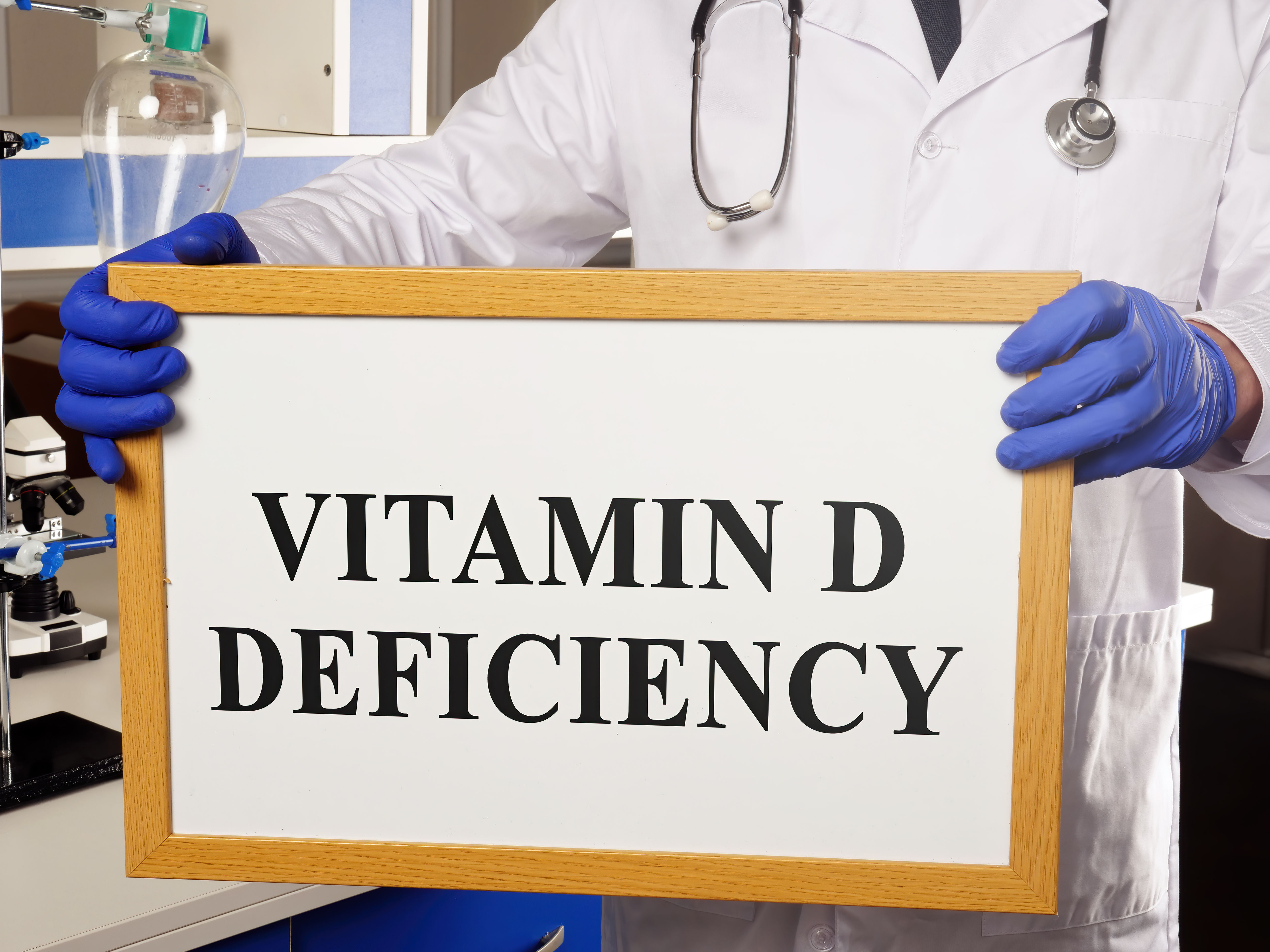 Doctor writing a vitamin D deficiency diagnosis on a whiteboard, representing how common vitamin D deficiency is among postpartum women and why testing matters before supplementing