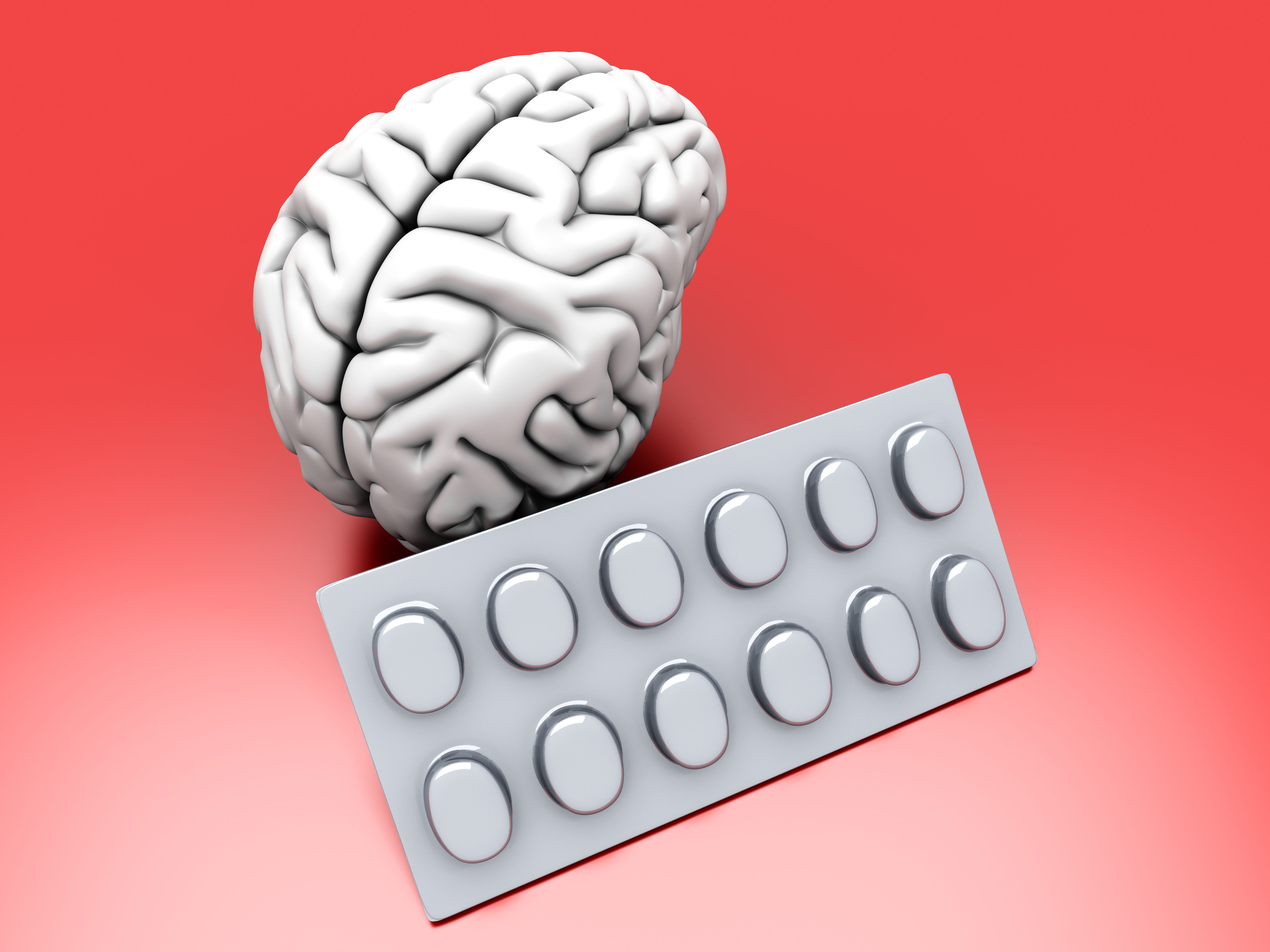 Human brain model alongside supplement pills and capsules representing nootropic compounds — illustrating the science of cognitive enhancement, neurotransmitter support, and brain energy metabolism that underpins the nootropic Brainergy shot concept