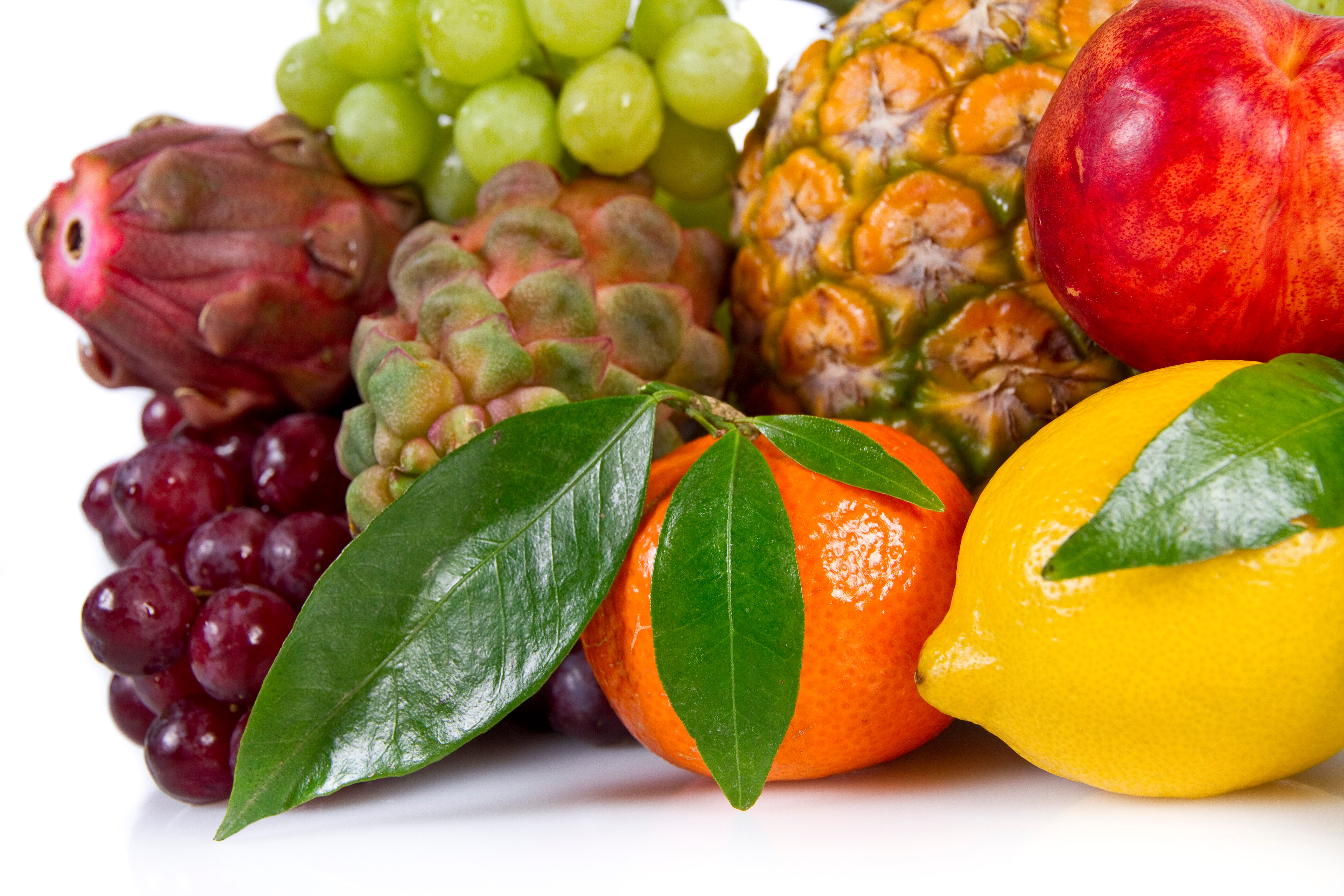 Fresh colorful assortment of fruits including grapes, oranges, apples, and pineapple representing the antioxidants and vitamins that matter at every decade of life