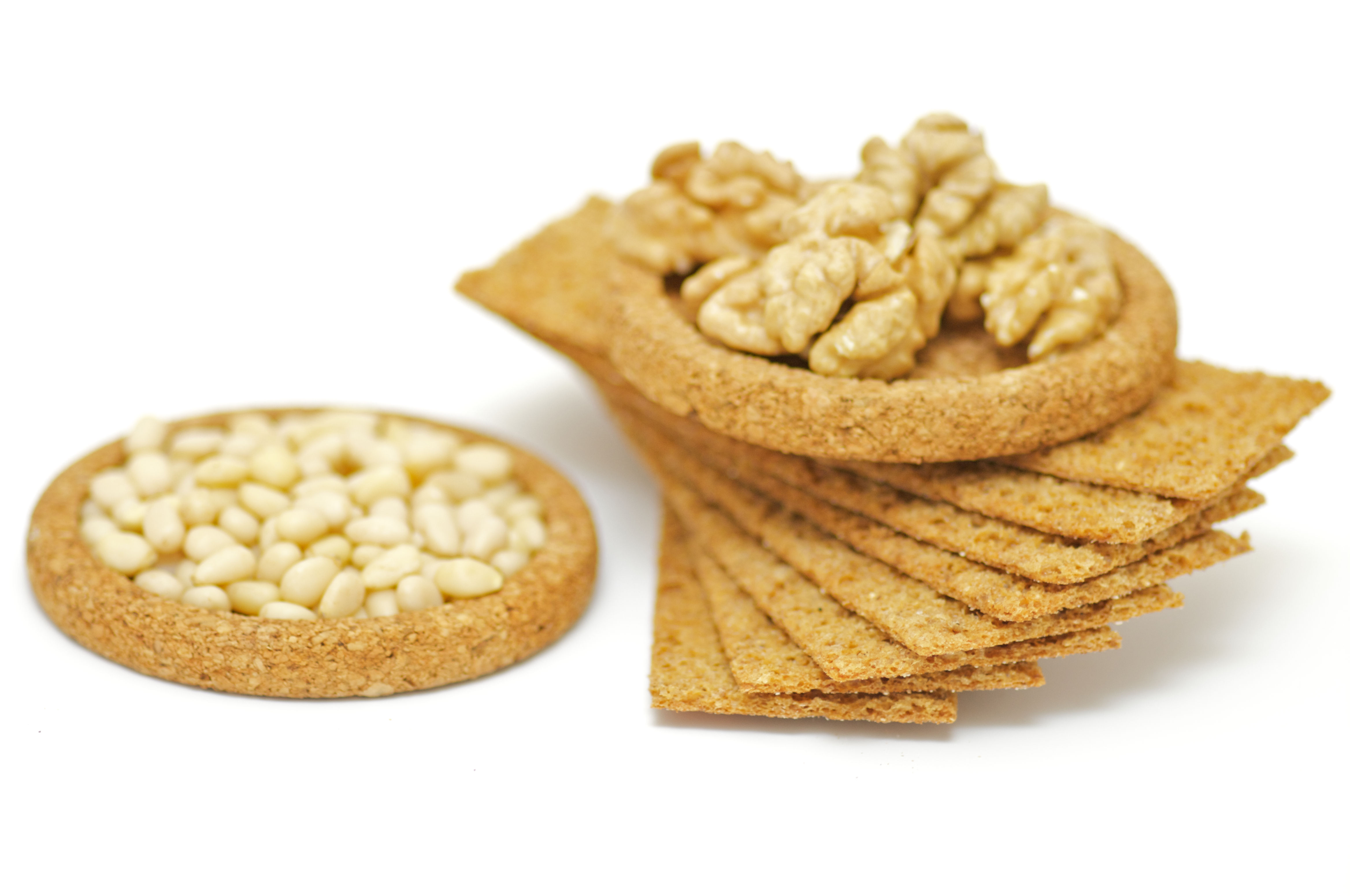 Whole grain crispbread with peanuts and pine nuts representing the foundation of a balanced daily nutrition plan across all decades — providing B vitamins, magnesium, healthy fats, and fiber