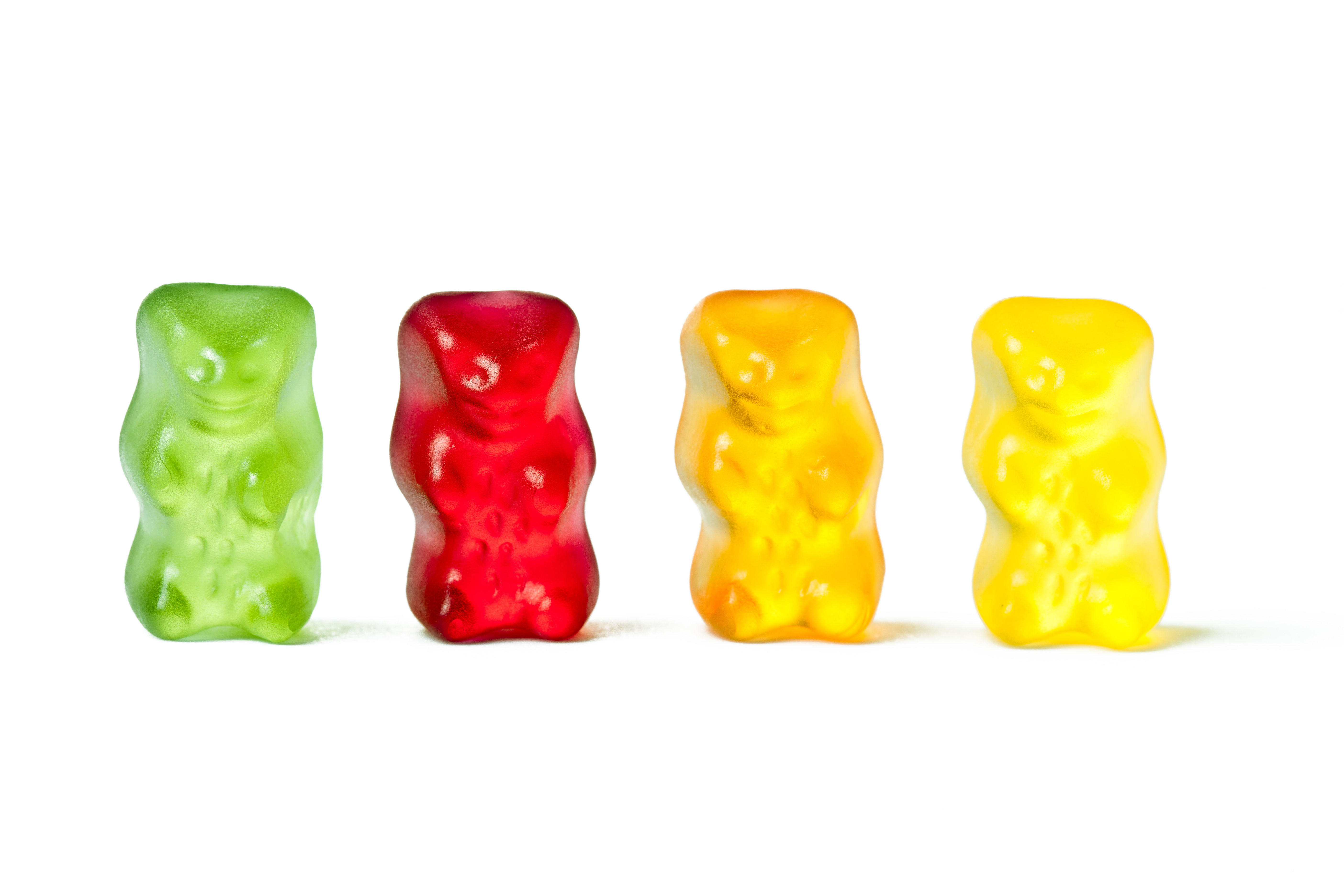 Colorful gummy bear vitamins in green, red, and yellow — gummy vitamins are the single largest source of hidden added sugar in the supplement industry, often requiring 2-4 gummies per serving