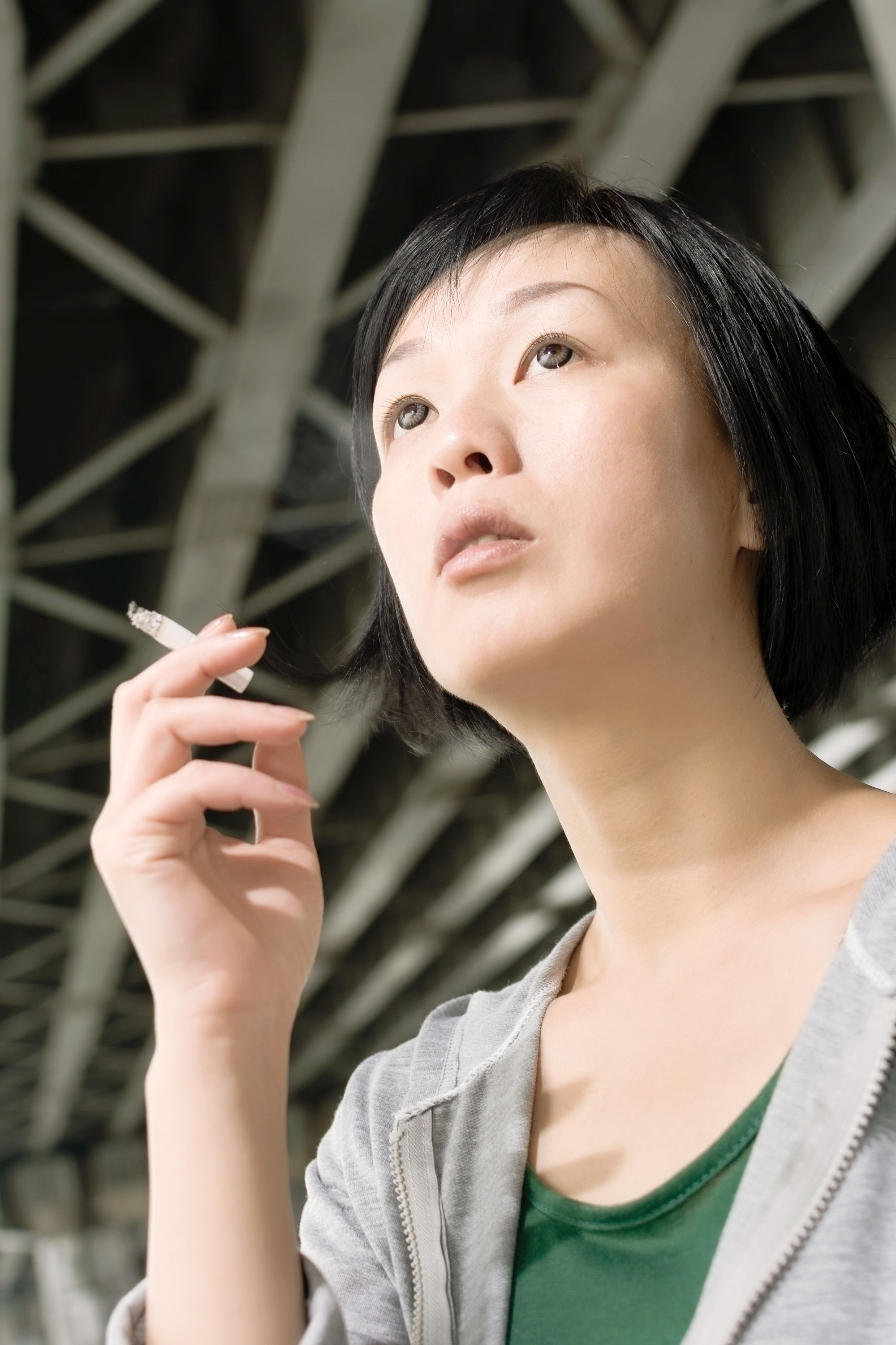 Woman smoking a cigarette outdoors — smoking directly damages collagen and elastin fibers and is one of the key lifestyle factors that accelerate collagen decline beyond normal aging