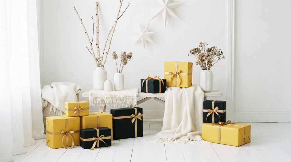 Yellow and black gift boxes with gold ribbons in a bright white living room