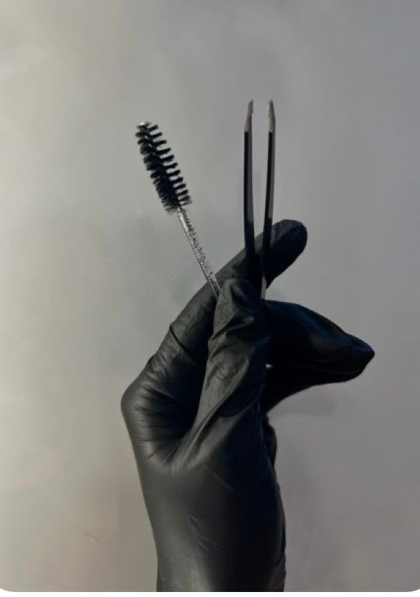  lash tools,tweezers,spoolie,beauty treatment,cosmetic procedure,close-up,professional equipment,black glove,neutral background 