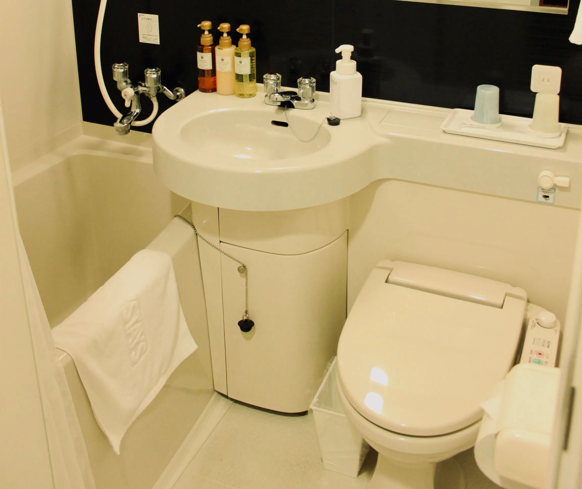 alt="Japońska łazienka z nowoczesną toaletą typu washlet i głęboką wanną ofuro"