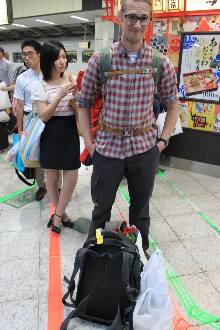 Osoby oczekujące na peronie w Tokyo Station City, ustawione według linii na podłodze, z pierwszym stojącym Stefanem
