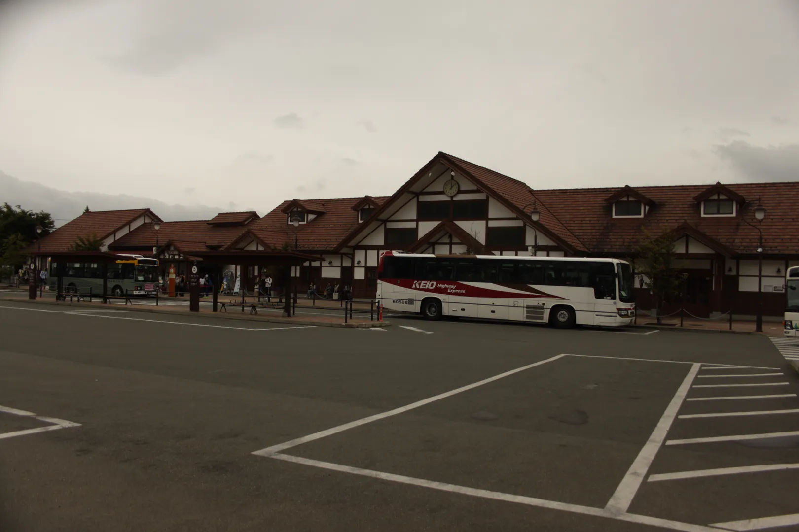 Stacja 5 u podnóża góry Fuji, widoczny budynek w alpejskim stylu oraz zaparkowany autobus turystyczny.