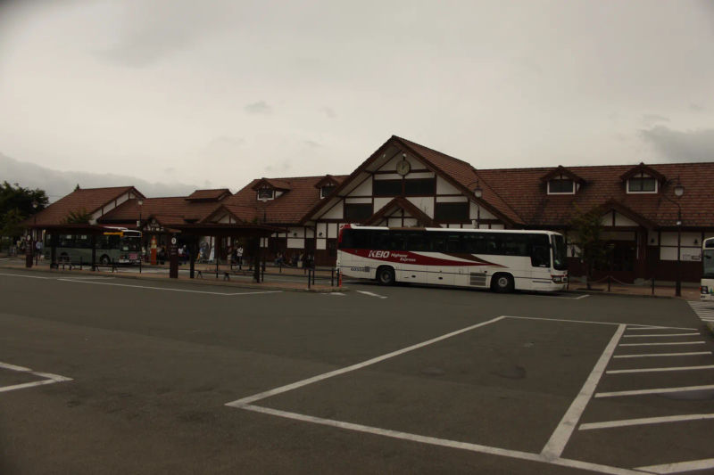 Stacja 5 u podnóża góry Fuji, widoczny budynek w alpejskim stylu oraz zaparkowany autobus turystyczny.