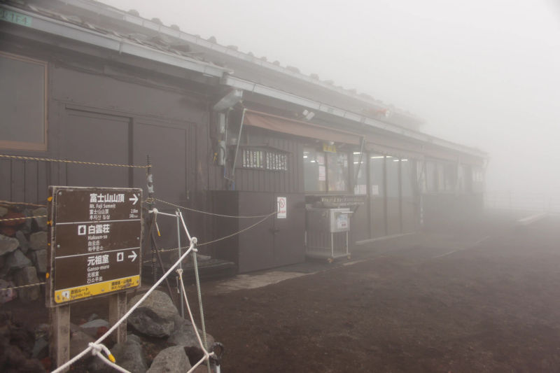 Mgliste i deszczowe warunki na szlaku górskim na górze Fuji, w pobliżu schroniska.