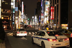 Nocny widok na ulice Ginzy z neonami i samochodami, Tokio, Japonia
