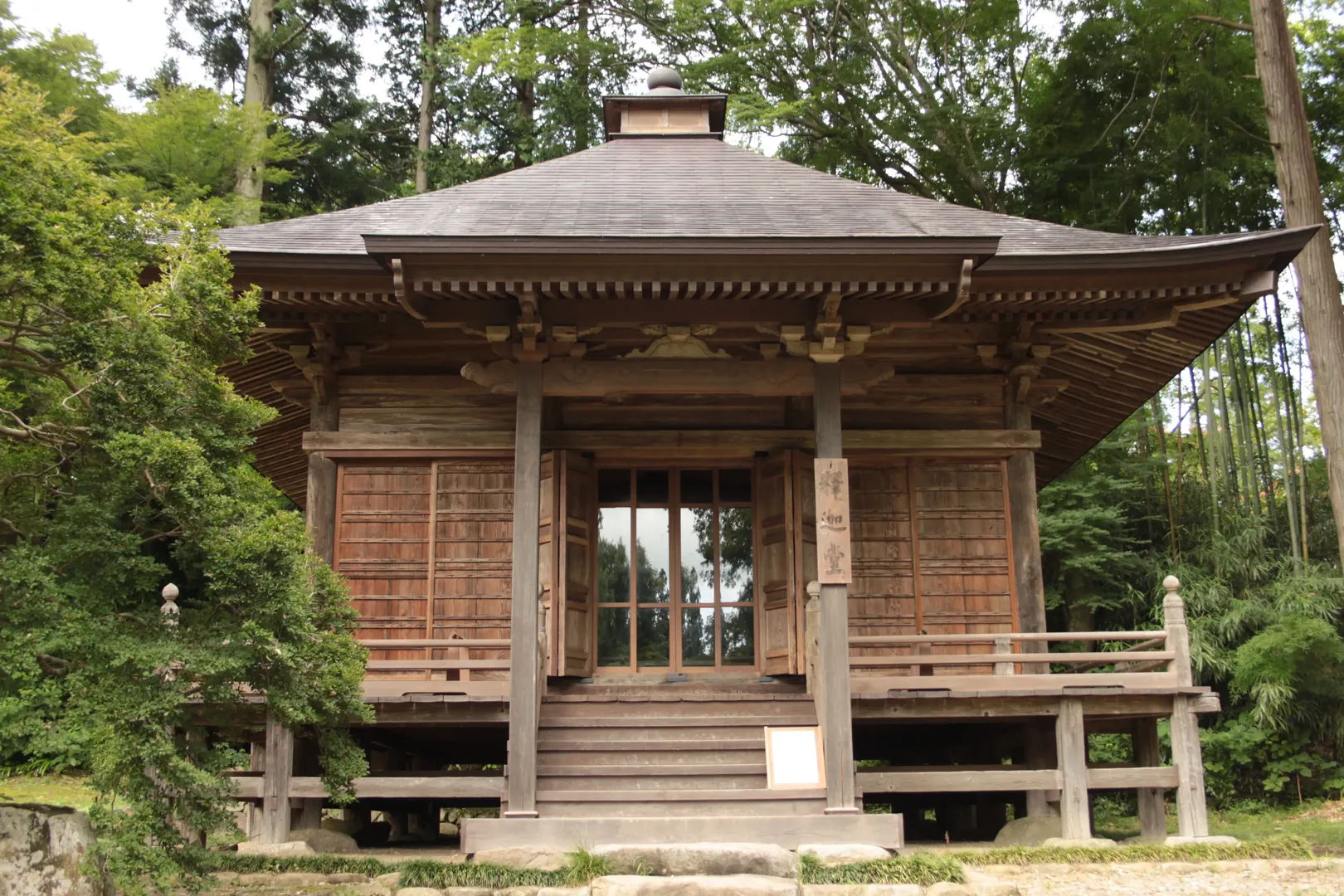 Tradycyjny drewniany pawilon w świątyni Chuson-ji w Hiraizumi, otoczony drzewami
