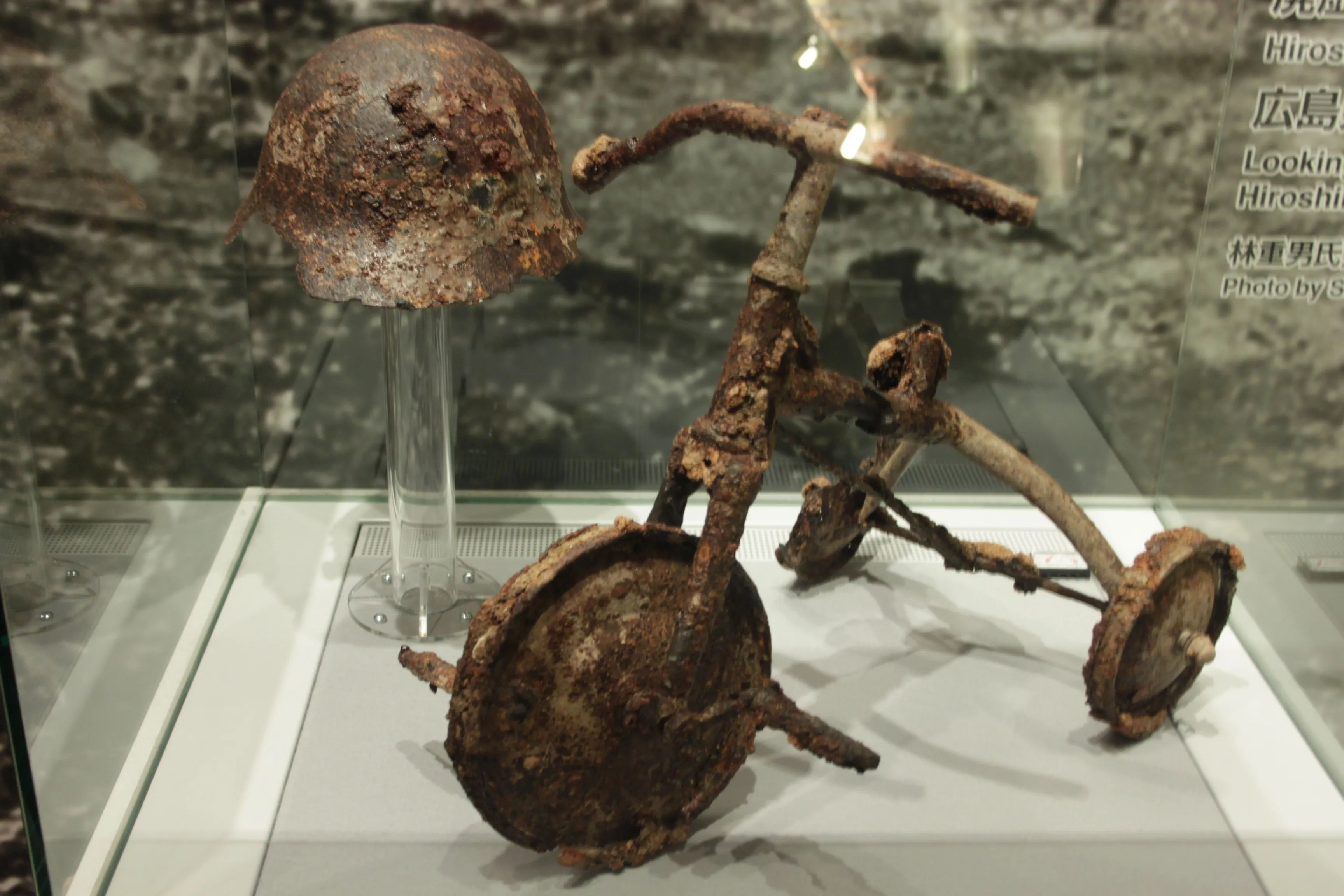 Zardzewiały trójkołowy rowerek dziecięcy wystawiony w Muzeum Pokoju w Hiroszimie.