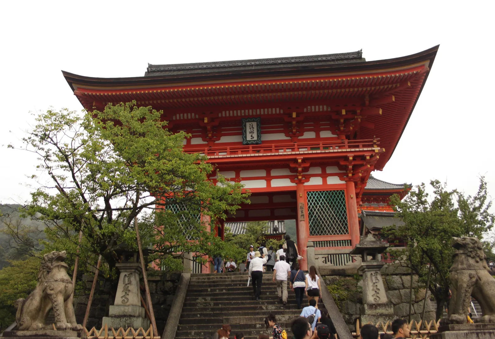 Główne wejście do świątyni Kiyomizu-dera, ozdobione czerwonymi drewnianymi strukturami.
