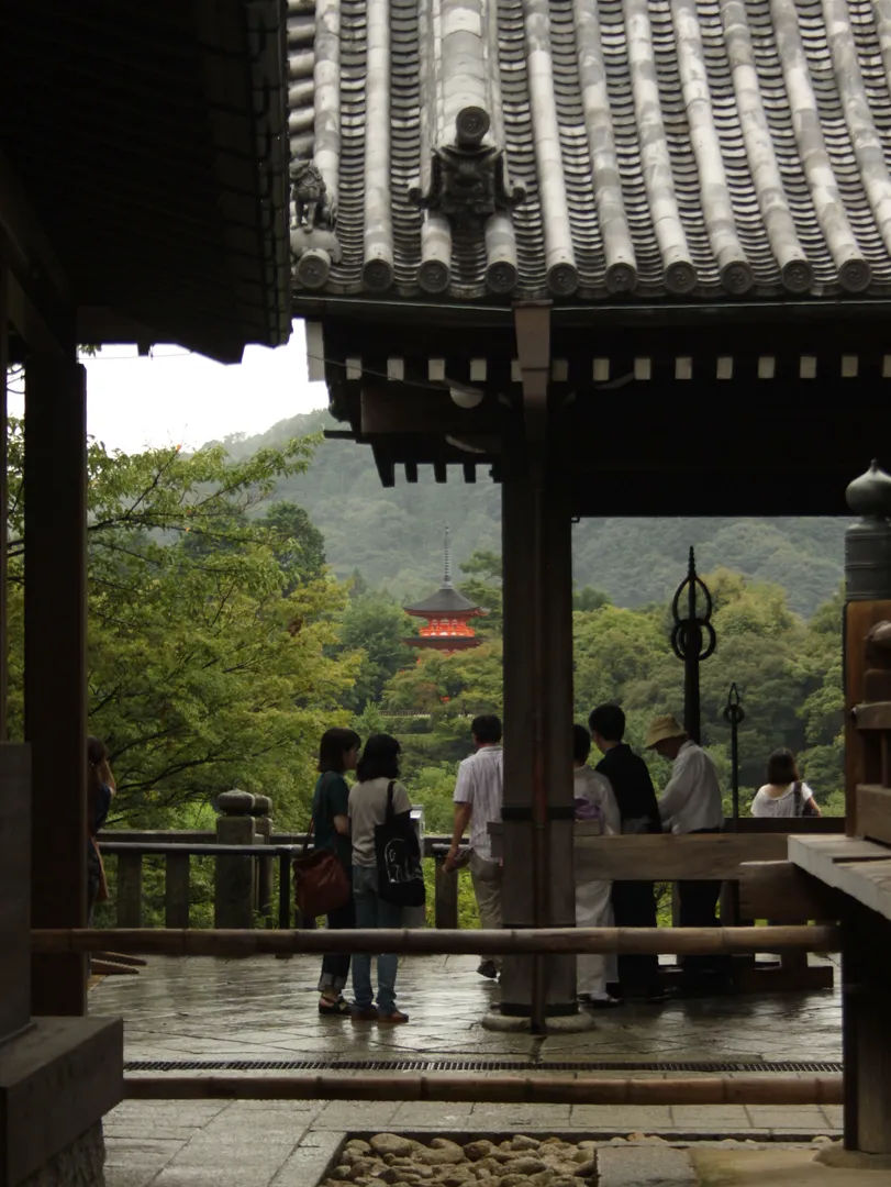 Widok na otoczenie świątyni Kiyomizu-dera, z drzewami i pagodą w tle.