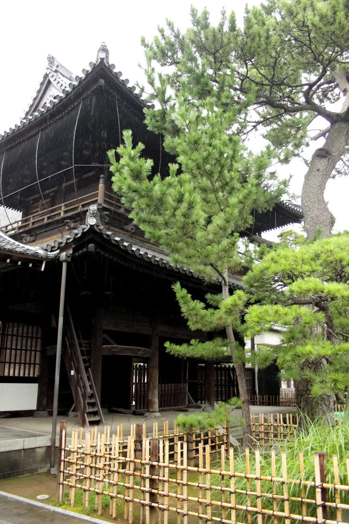 Fragment tradycyjnej świątyni Sengaku-ji, otoczony zielenią.