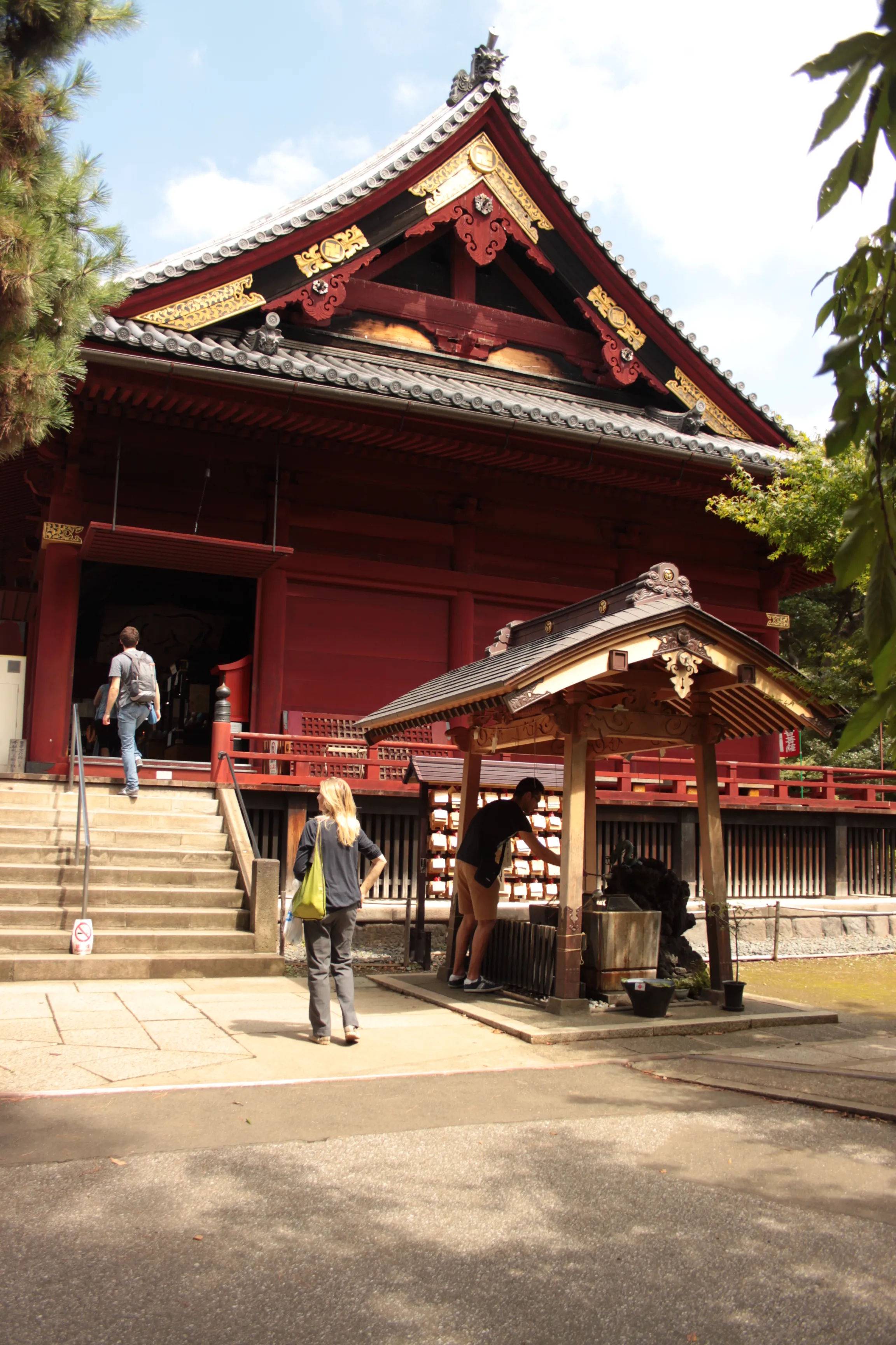 Wejście do buddyjskiej świątyni Kiyomizu Kannon w Tokio, z ludźmi wchodzącymi po schodach