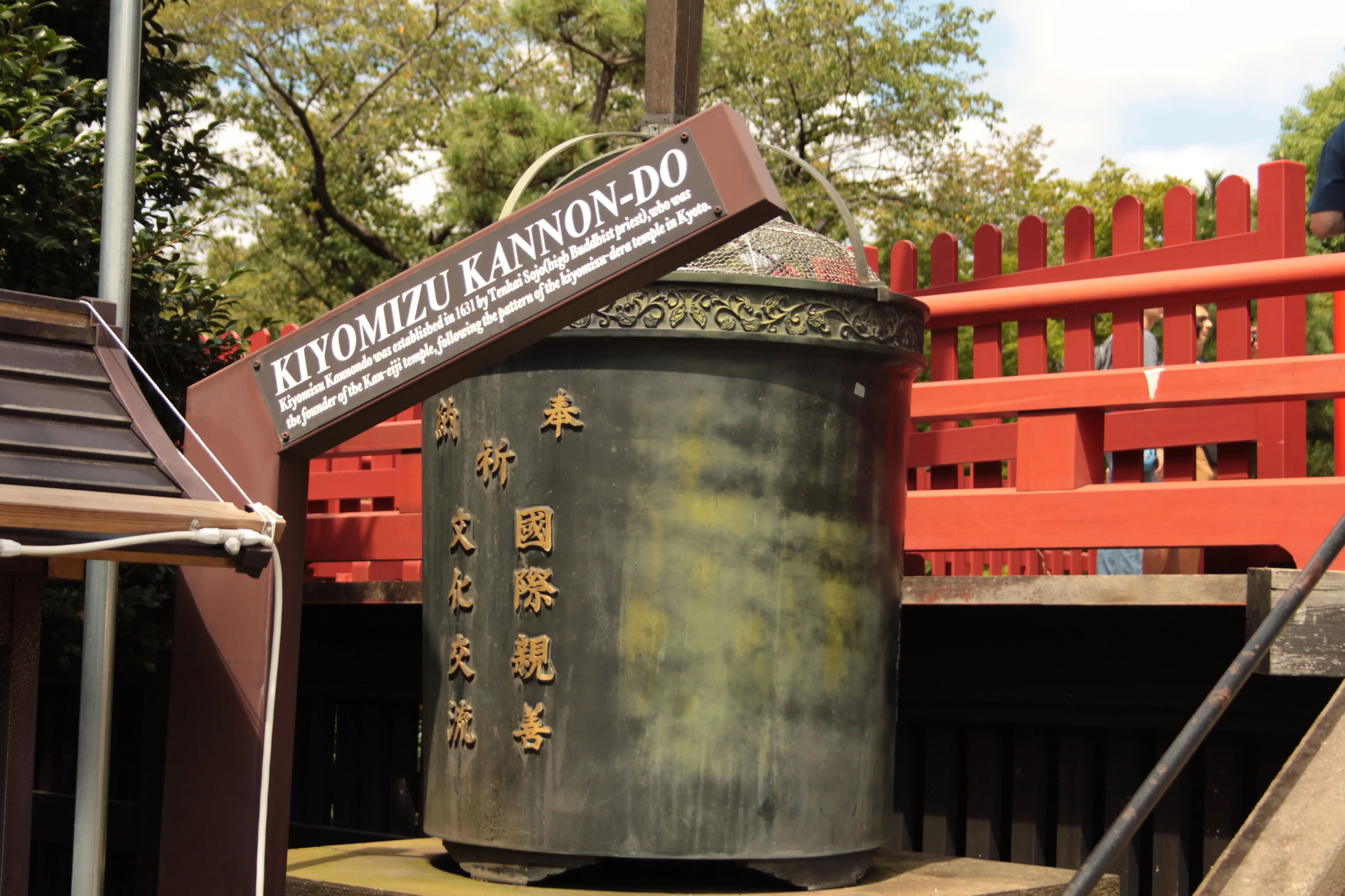 Tablica i dzwon przy świątyni Kiyomizu Kannon w Tokio, z napisem w języku japońskim i angielskim
