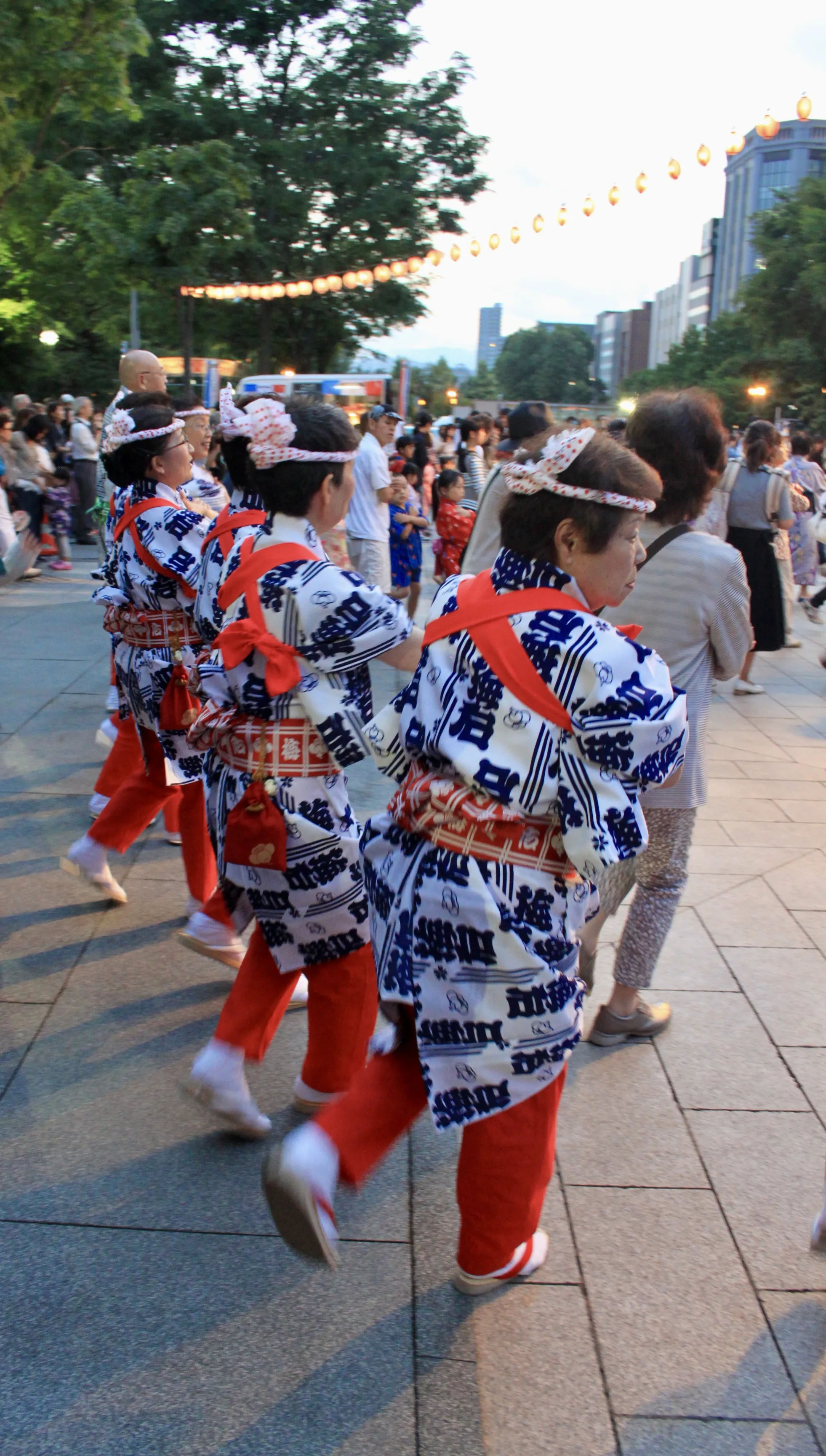 Trzy kobiety w czerwonych spodniach tańczące do muzyki Bon Odori