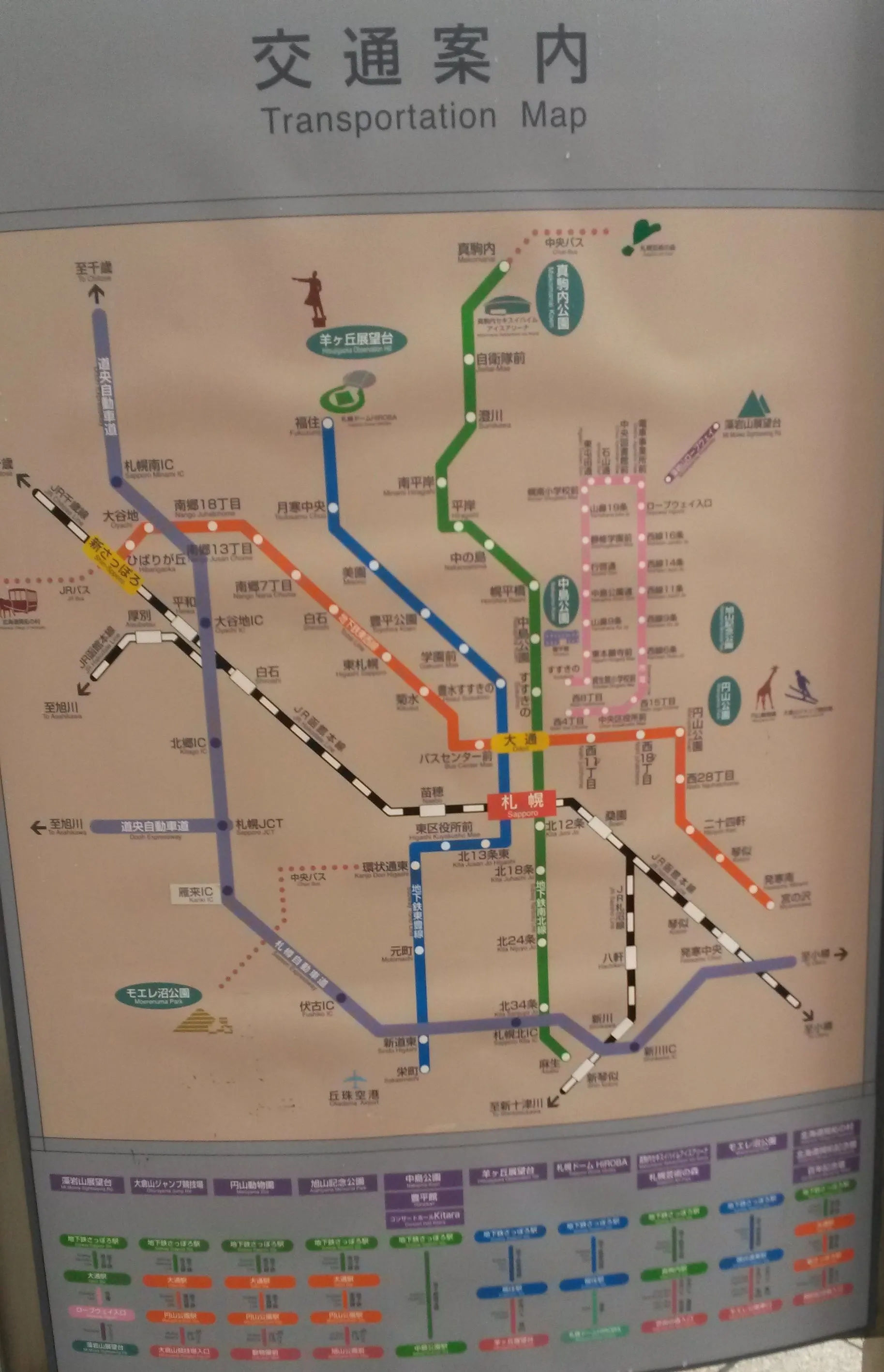 Kolorowy tramwaj jadący przez Sapporo z wieżowcami w tle