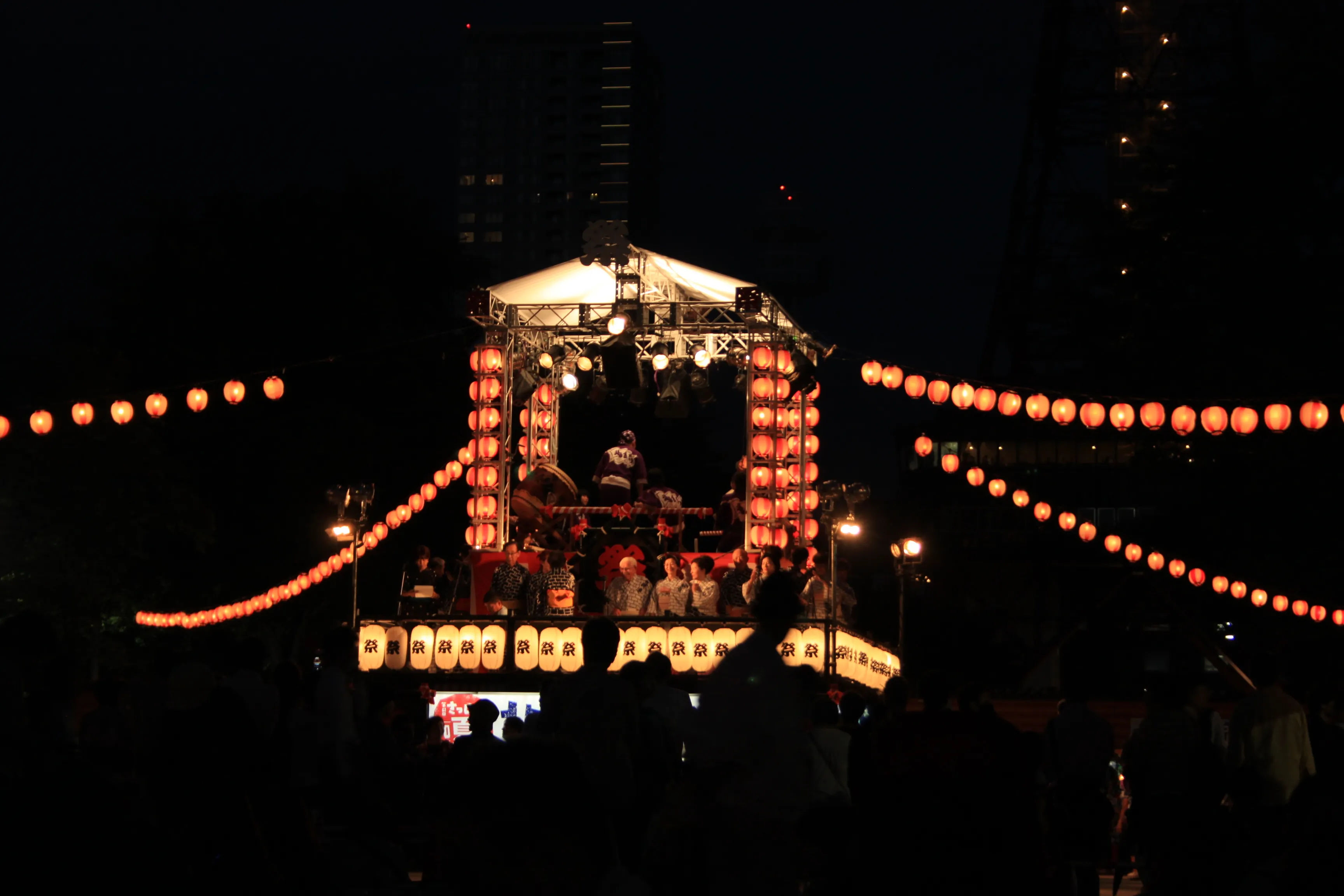 Oświetlona scena podczas festiwalu Bon Odori w Parku Odori w Sapporo, zdjęcie wykonane w nocy