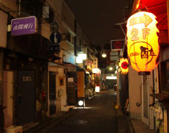 Wąska uliczka nocą w dzielnicy Shinjuku, Tokio, Japonia, oświetlona tradycyjnymi lampionami