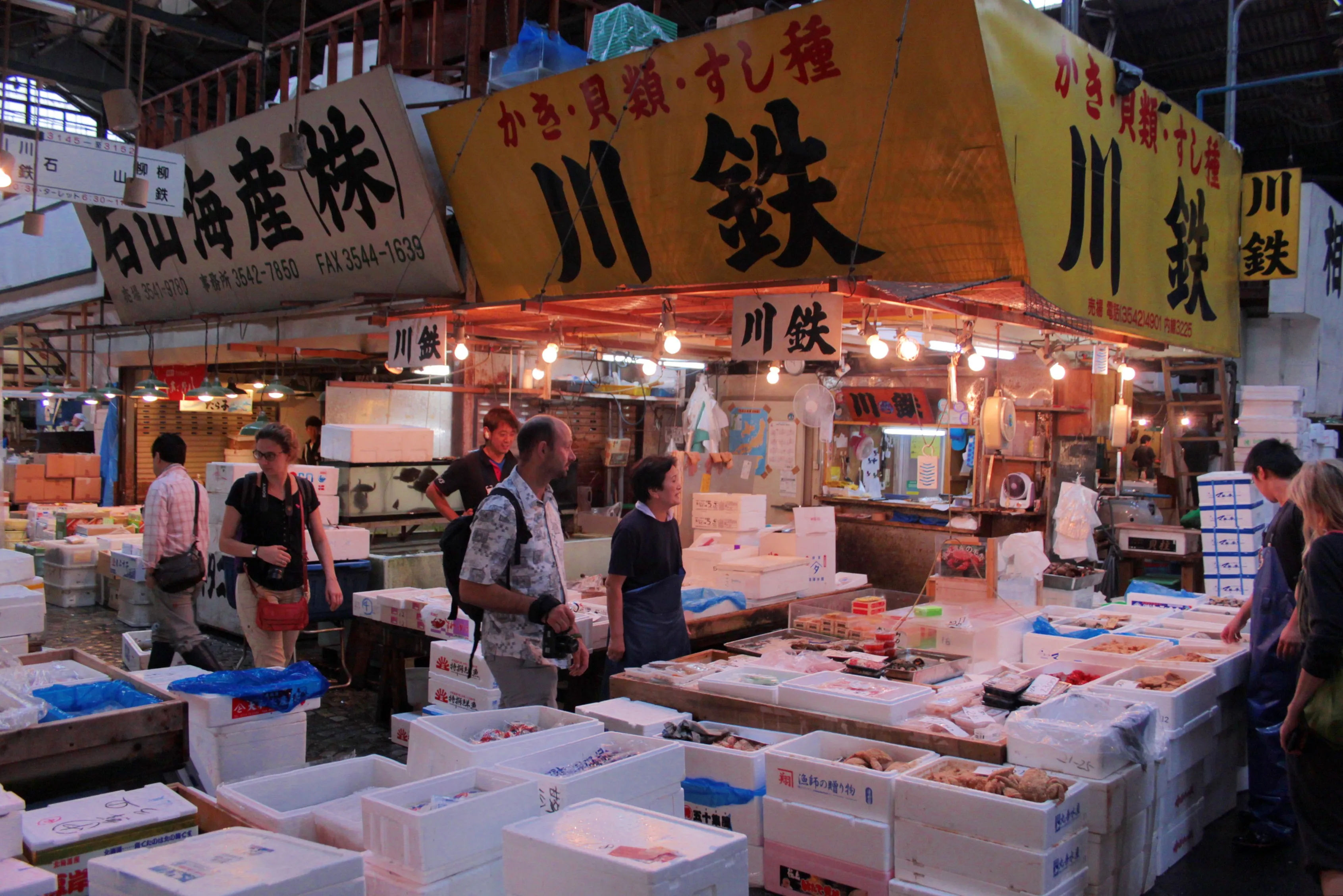 Ruchliwa część Tsukiji Market, z licznymi stoiskami i klientami.