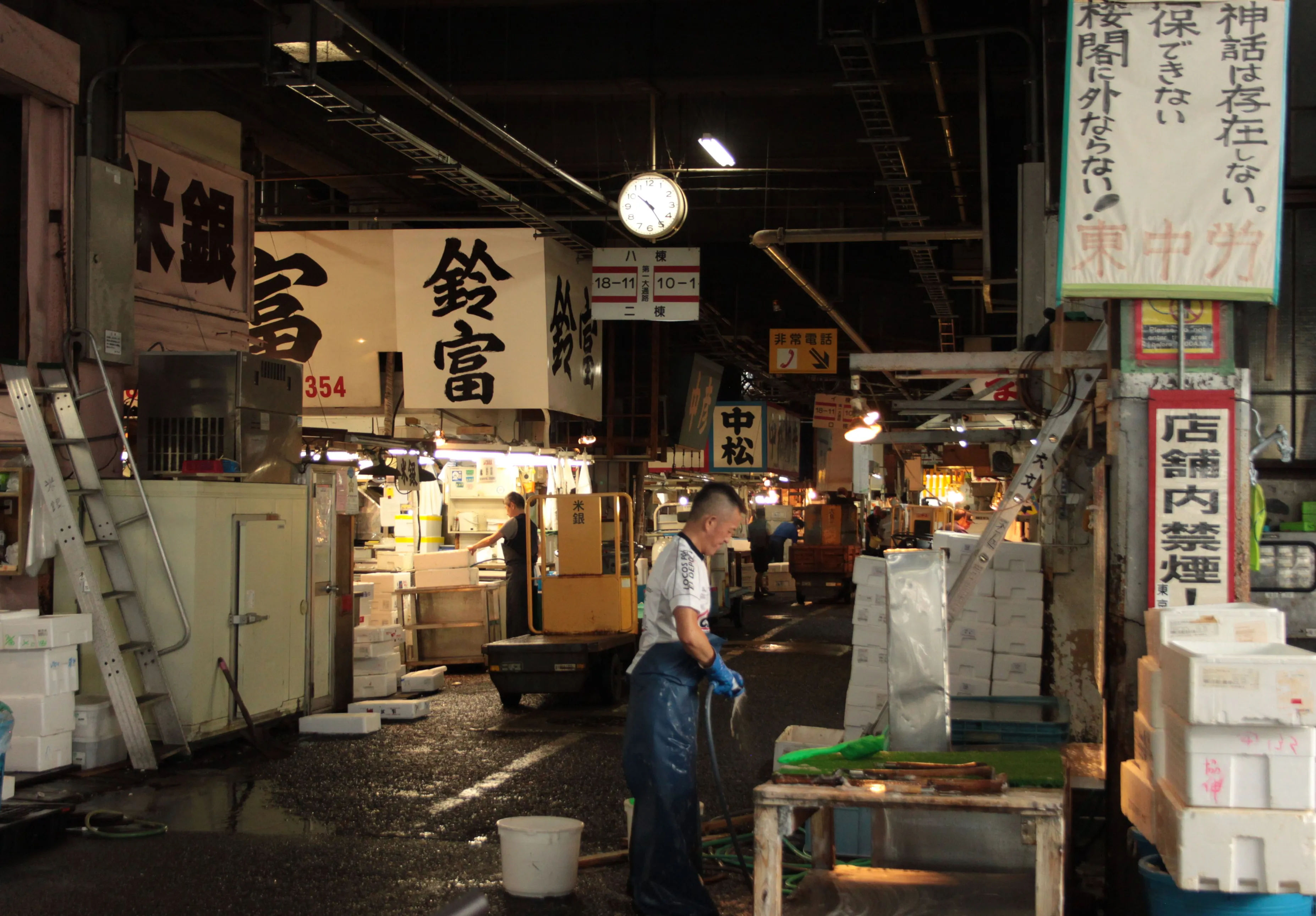 Stoiska z owocami morza w Tsukiji Market, z widocznymi sprzedawcami i klientami.