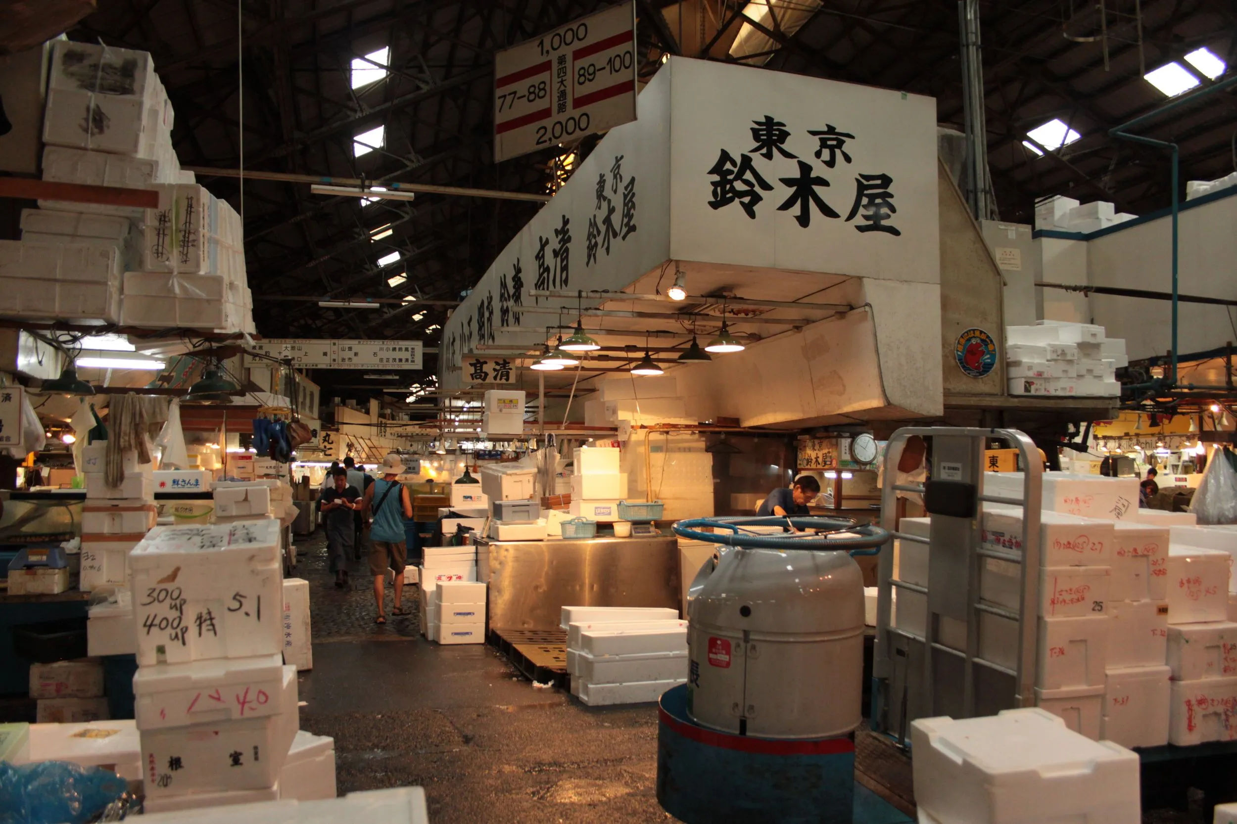 Główna hala Tsukiji Market, z dużą ilością skrzyń i oznaczeń stoisk.
