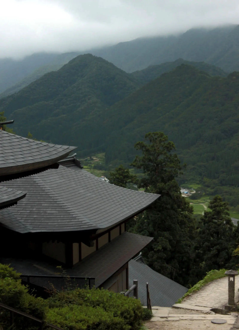 Dach światyni na wzgórzu z widokiem na dolinę i zalesione góry