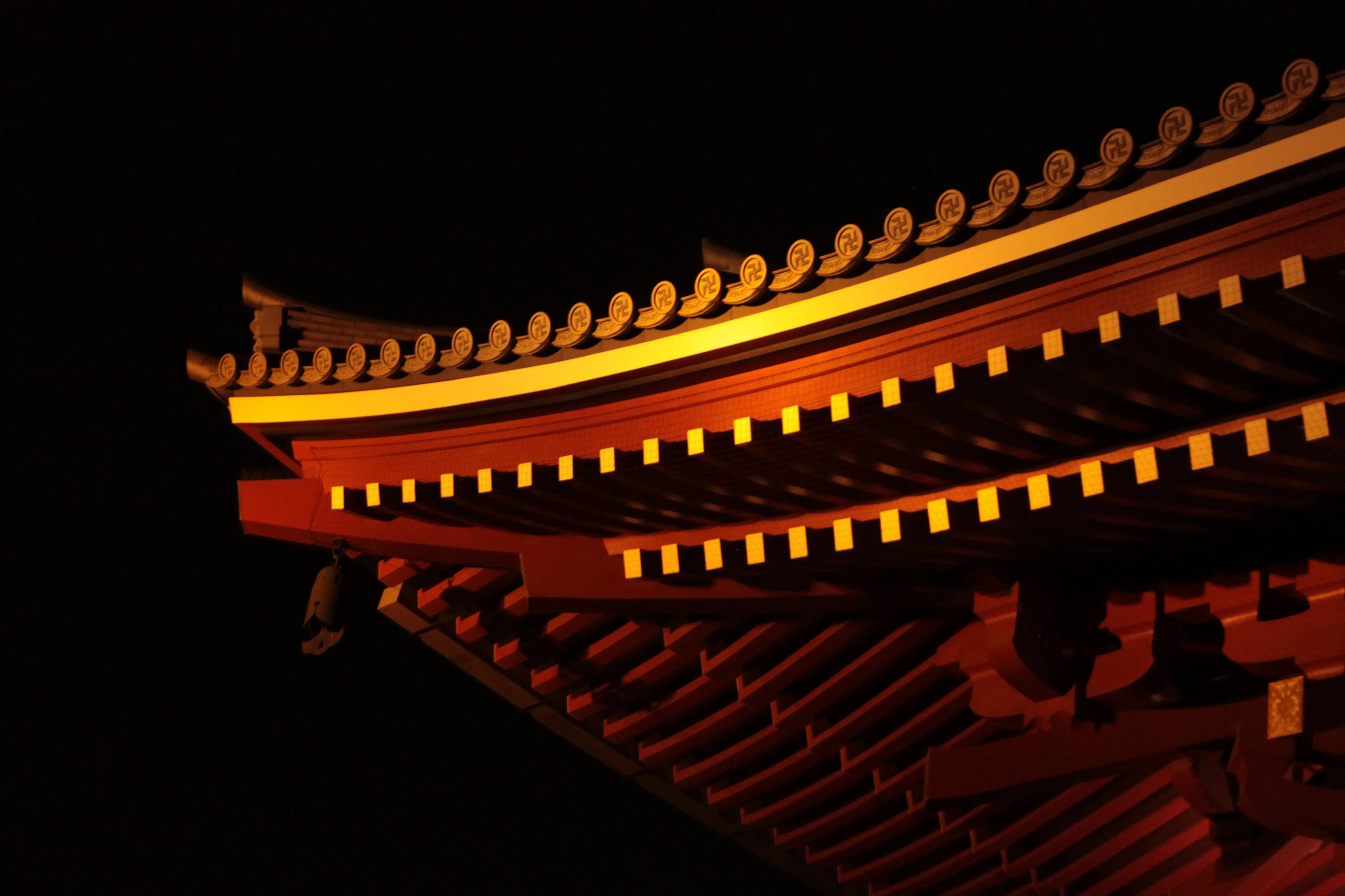 Oświetlona pagoda przy świątyni Sensō-ji nocą, widoczny dach