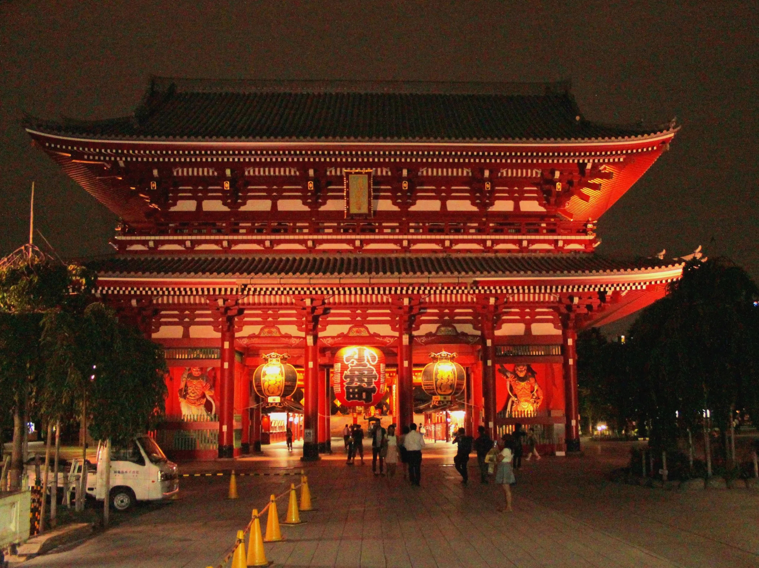 Nocny widok na oświetloną świątynię Sensō-ji i wrota Hozomon w Tokio, z czerwonymi lampionami przy wejściu.