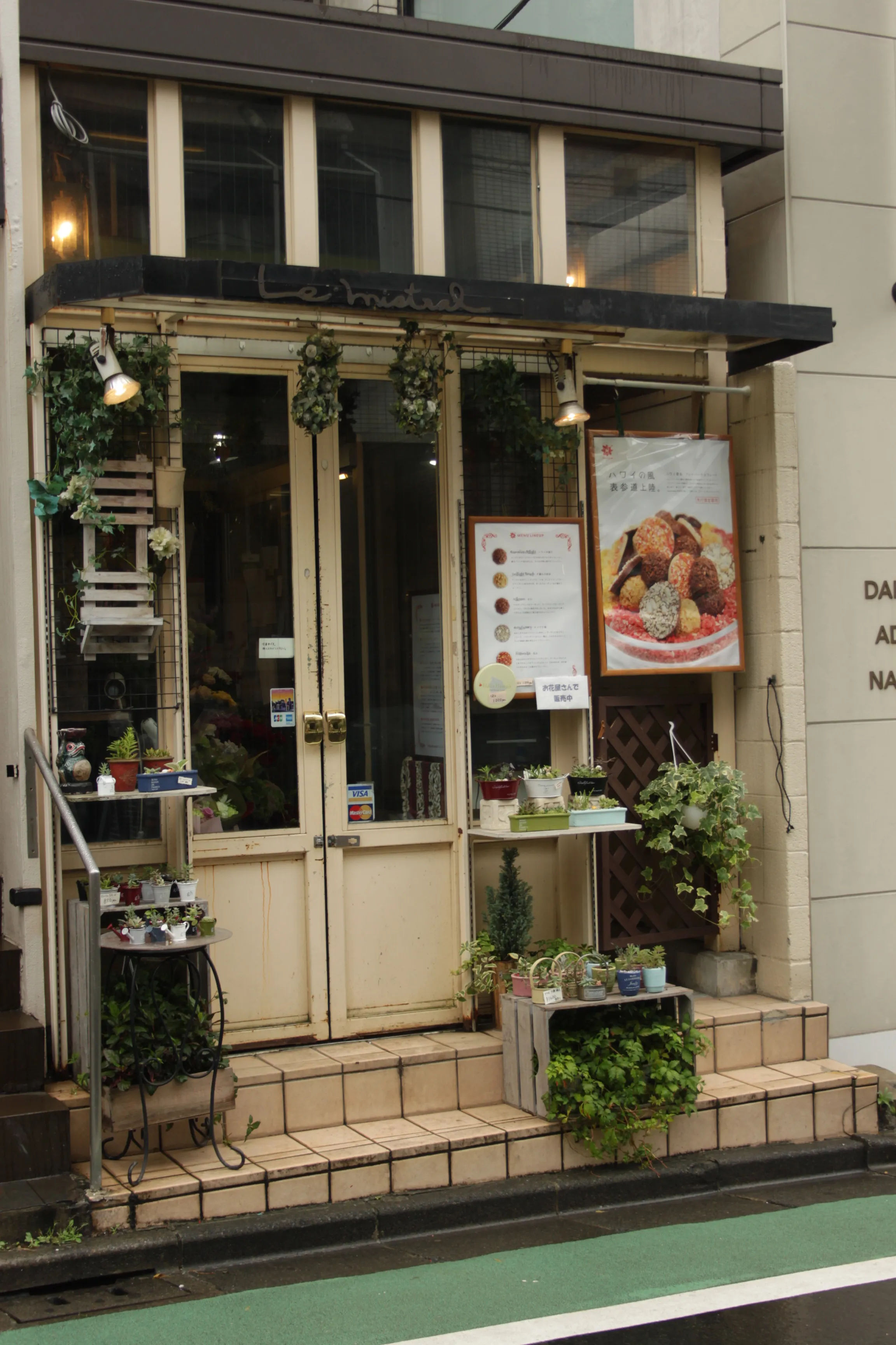 Restauracja przy ulicy Omotesando w Tokio, z wystawą ozdobioną roślinami.