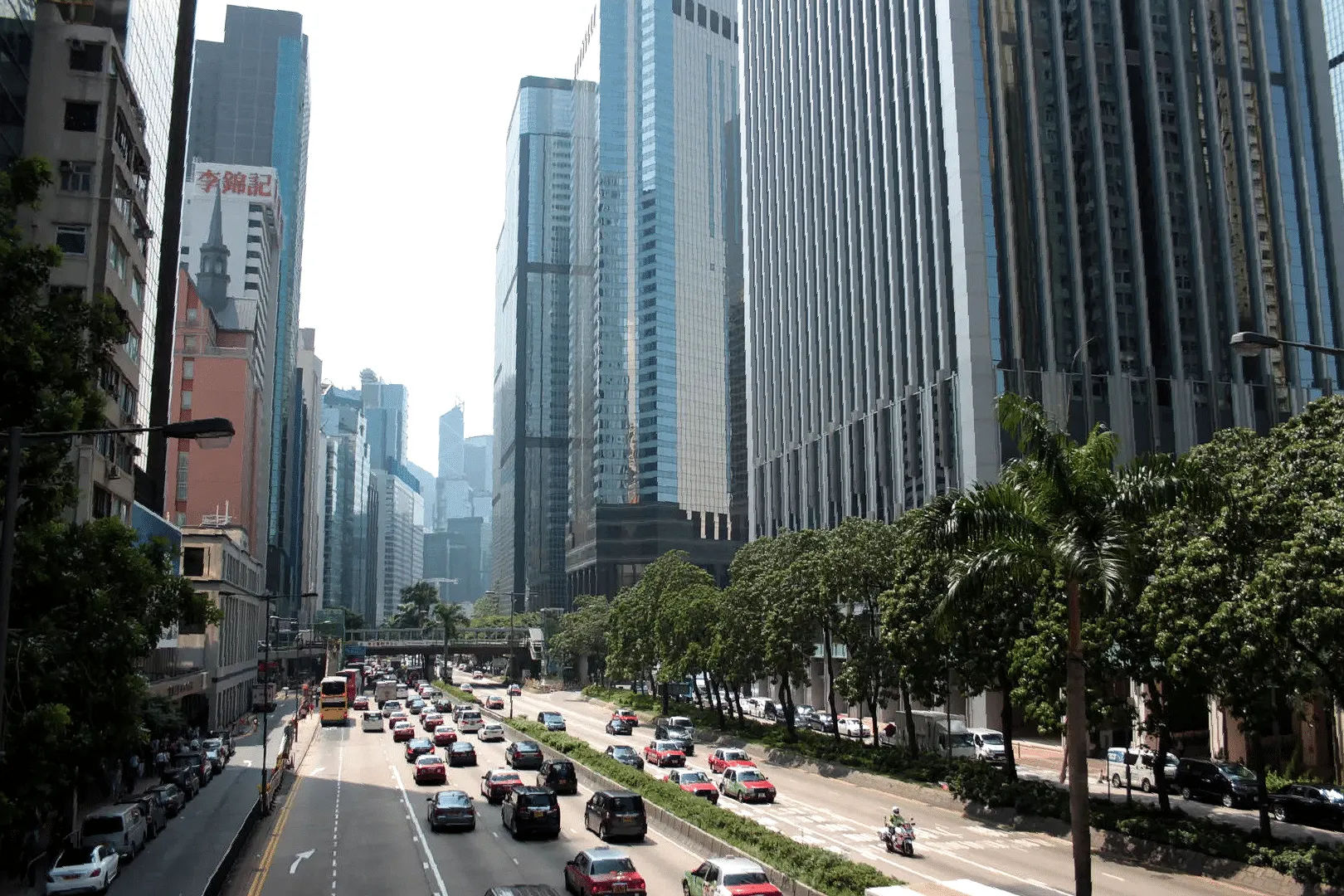 Ruchliwa ulica w centrum Hongkongu otoczona wysokimi wieżowcami